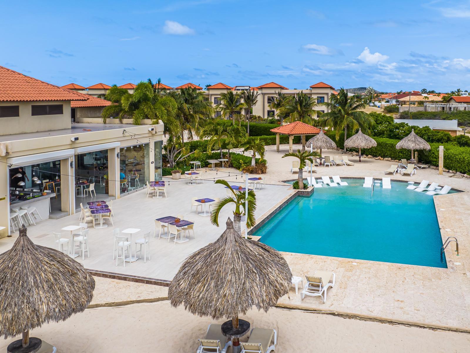 - Dive into relaxation at our resort's shared pool area in Noord, Aruba - Make new friends and enjoy social moments in the beautifully maintained shared pool area of our resort. - Take a dip in our resort's shared pool, with lush surrounding views.