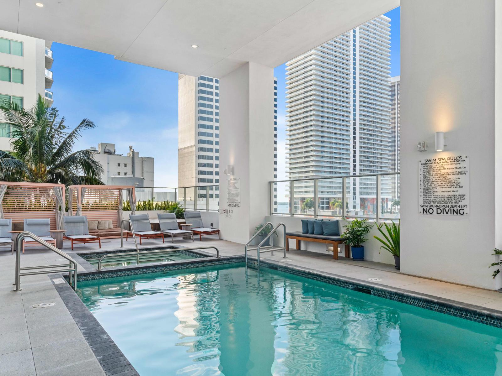 Pool deck with hot tub and sun beds