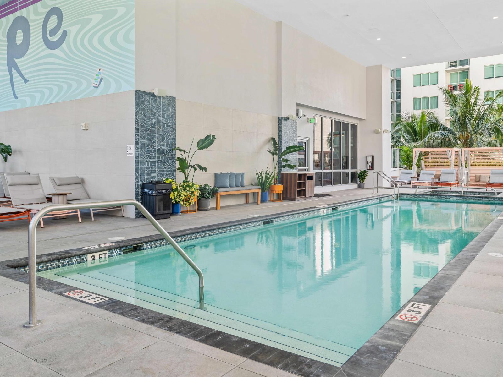 Pool deck with hot tub and sun beds