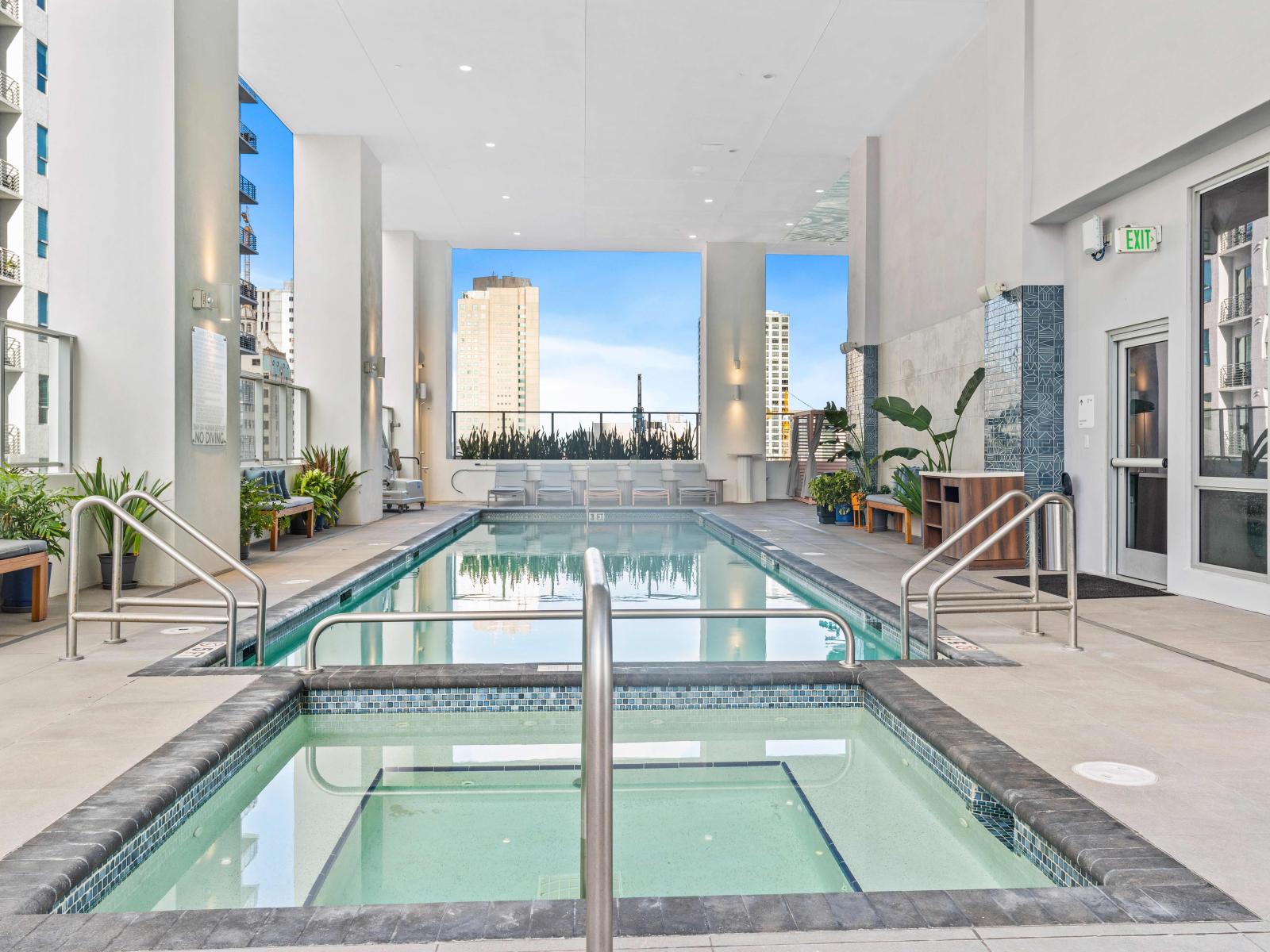 Pool deck with hot tub and sun beds