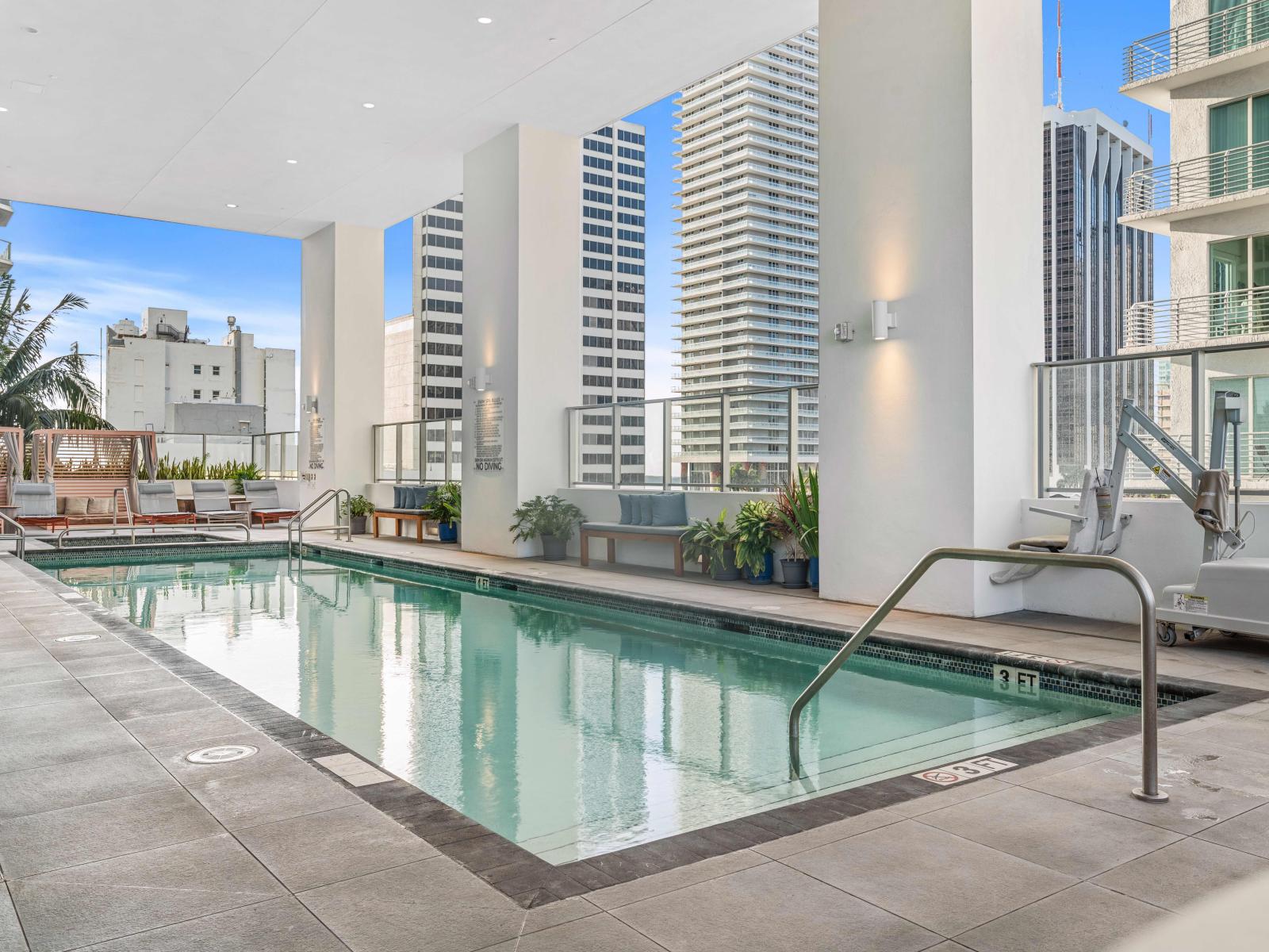 Pool deck with hot tub and sun beds