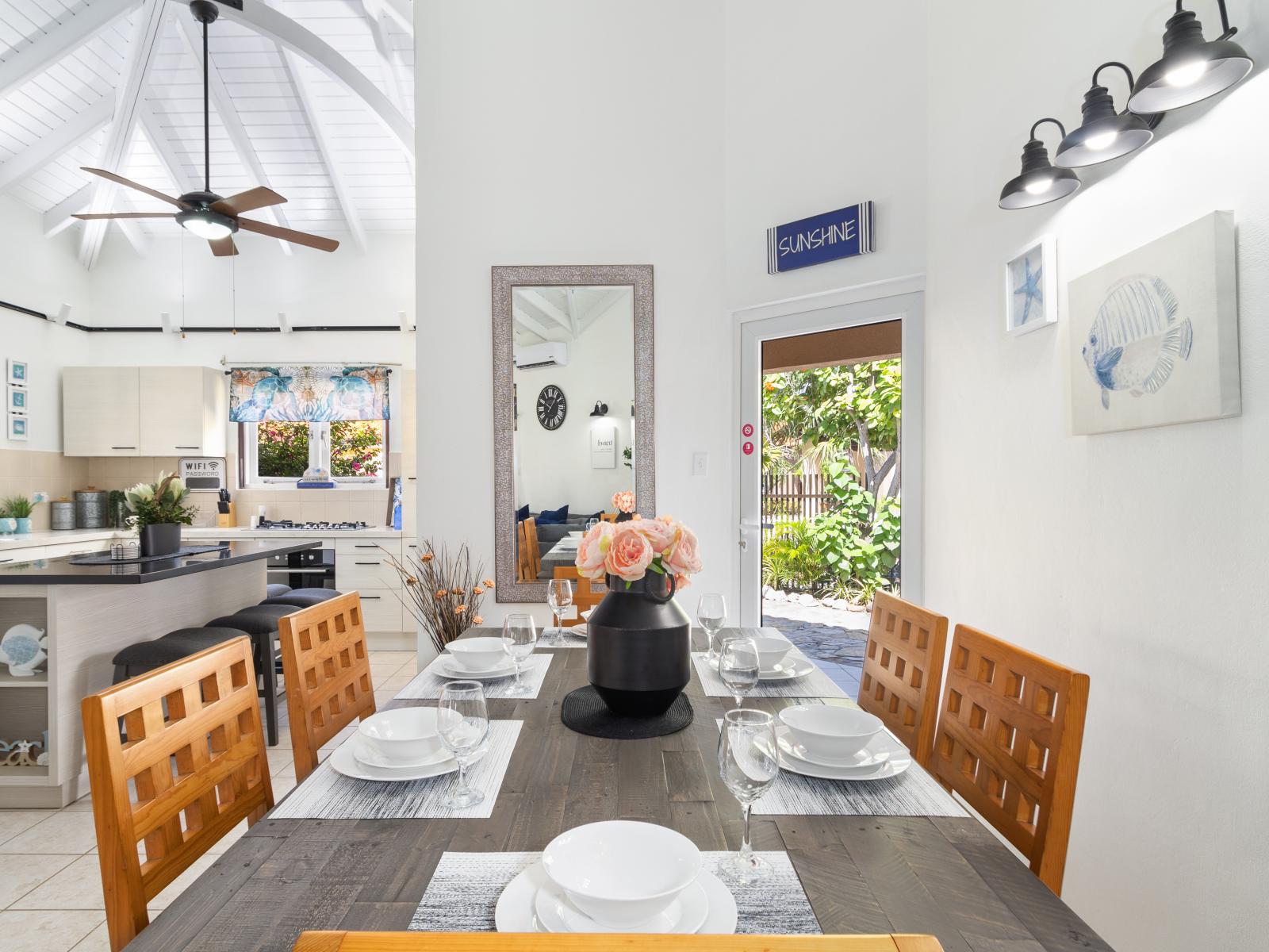 Marvelous dinning area of the 2BR Home in Noord, Aruba - Beautiful dinning area along with open kitchen - Elite 6 persons dinning - Stunningly located large glass door with mesmerizing views - Majestic decored with beautiful paintings and wall lamps