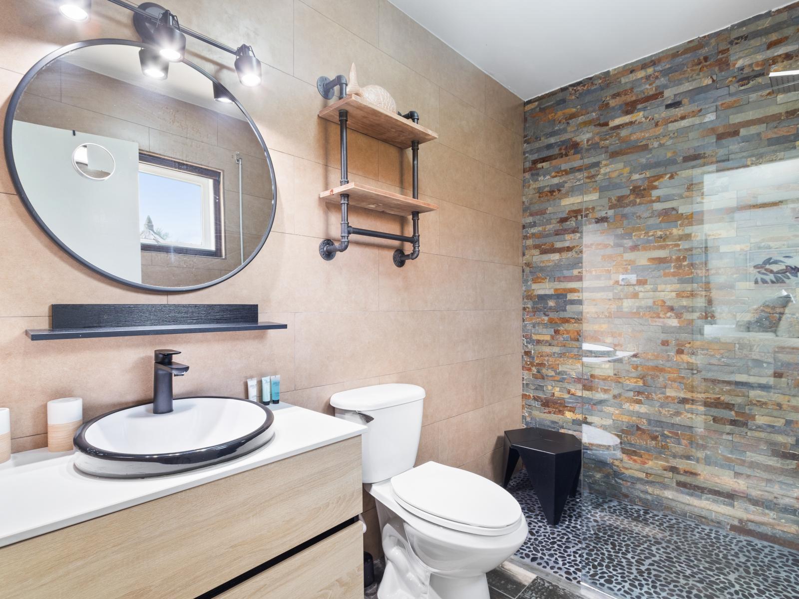 Well-Designed Bathroom of the 2BR Home in Noord Aruba - Chic design featuring a sleek vanity and upscale lighting - Walk-in Shower Area - Thoughtful storage solutions with stylish cabinets and shelves