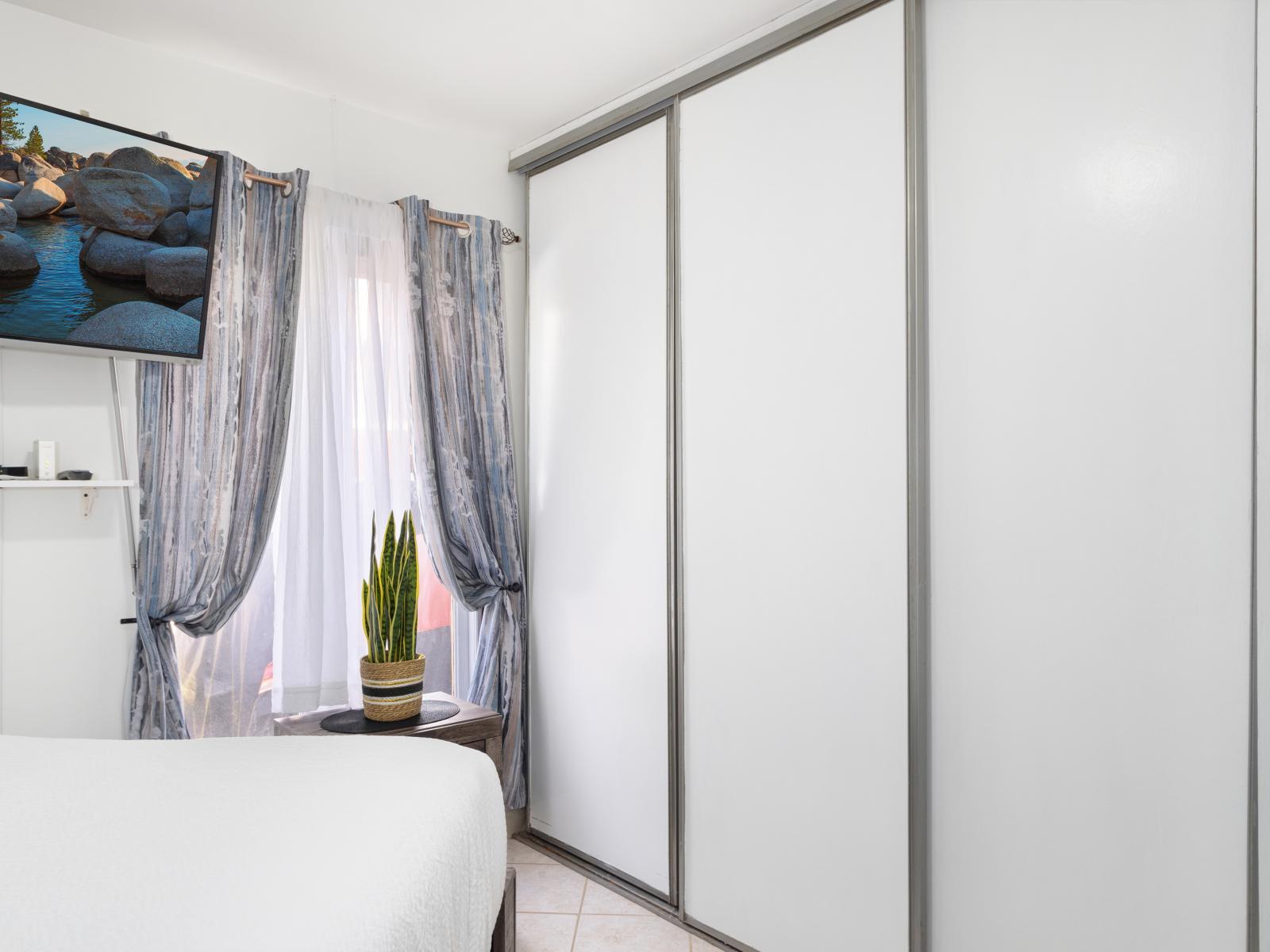 Modern Bedroom of the 2BR Home in Noord Aruba - Smart TV and Netflix - Plenty of storage with spacious closets with sliding doors -  Seamless blend of comfort, aesthetics, and functionality