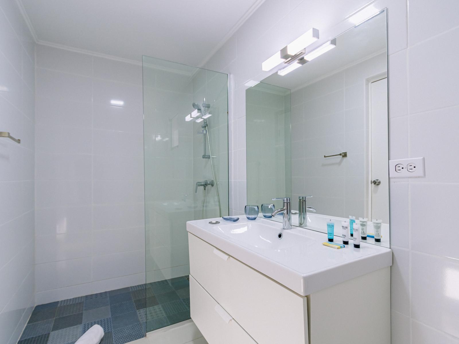 Superb Bathroom of the 4BR Home in Noord Aruba - Sophisticated color palette creating a serene ambiance - Contemporary fixtures for a touch of indulgence - Seamless design featuring a glass-enclosed shower