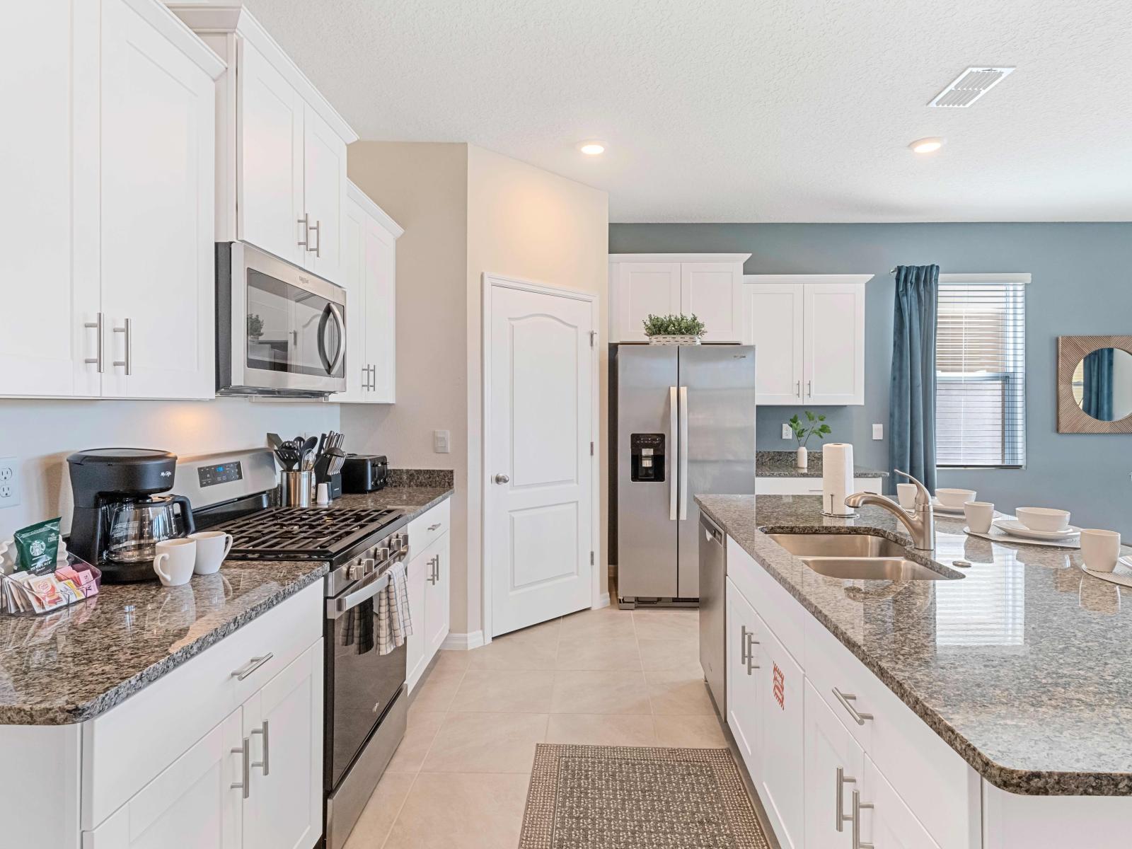 Polished kitchen of the home in Davenport Florida - Deluxe Stainless Steel Appliances - Plenty storage space for organized and clutter-free counters - Sufficient space to walk and work according to your ease