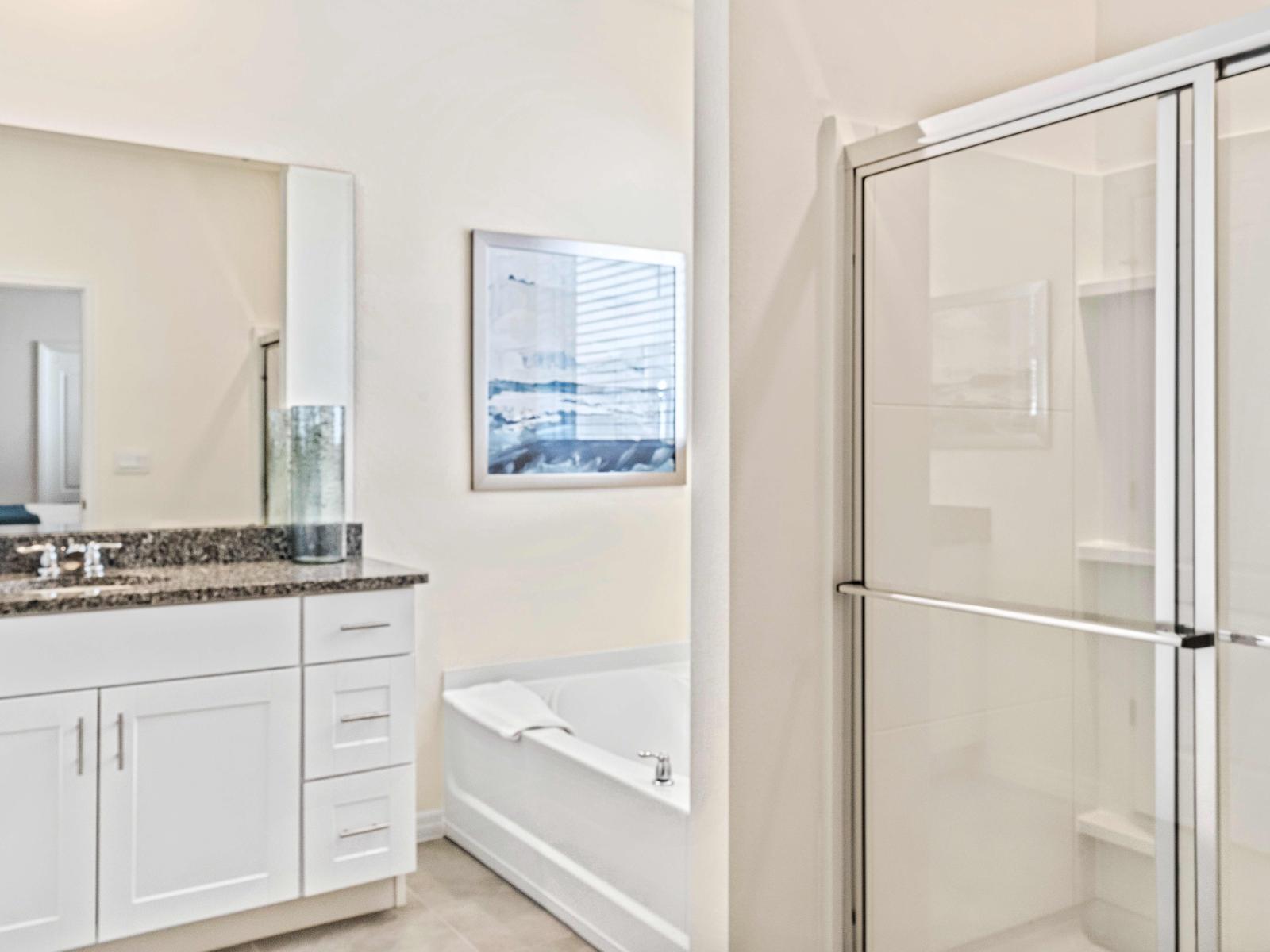 Chic bathroom of the home in Davenport Florida - Chic design featuring a sleek vanity and upscale lighting - Spa-like atmosphere with a modern, superb bathtub - Seamless design featuring a glass-enclosed shower for a modern touch