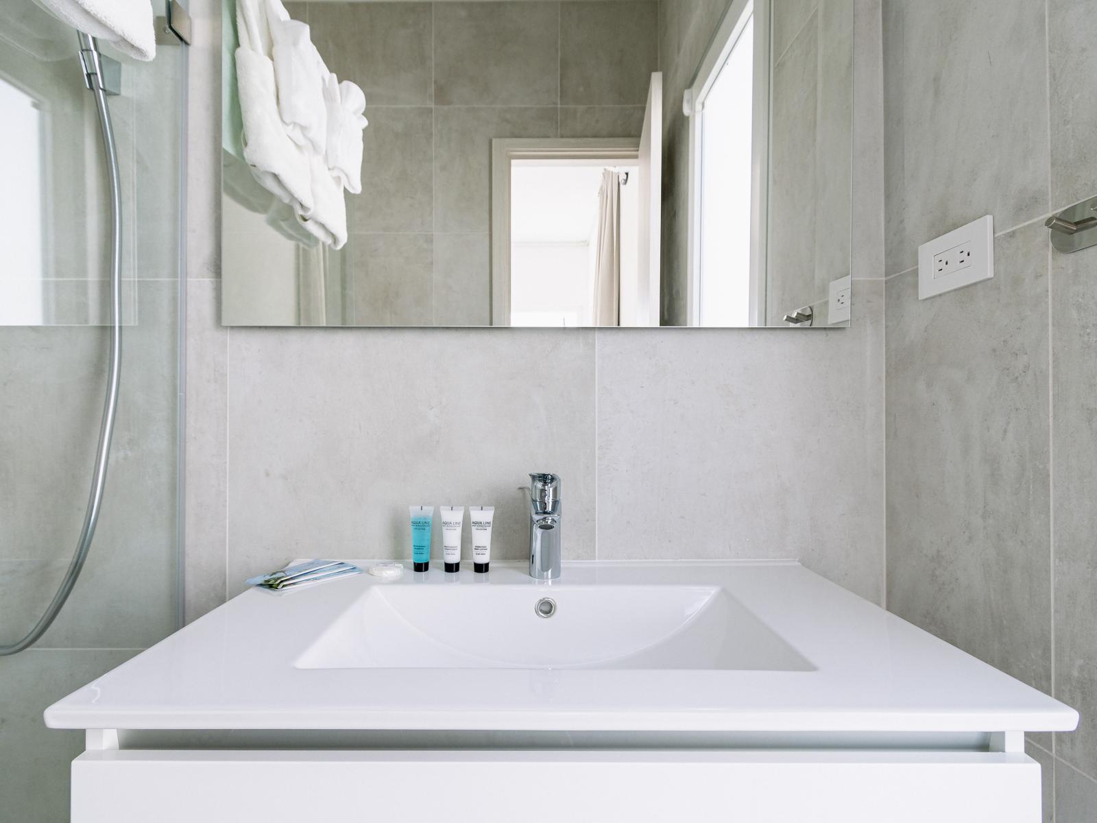 Tiled Bathroom of the Home in Oranjestad Aruba - Modern design touches - Luxe vanity with mirror - Walk-in Shower Area