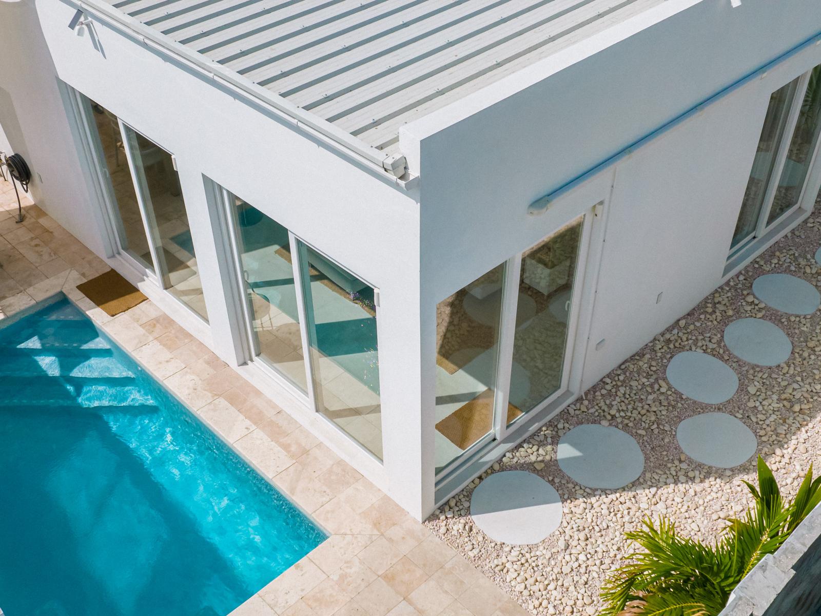 Lush Backyard of the Home in Oranjestad Aruba - Bird-eye View - Stone pathway - Outdoor Dining - Refreshing Pool Area - Tropical trees and plants