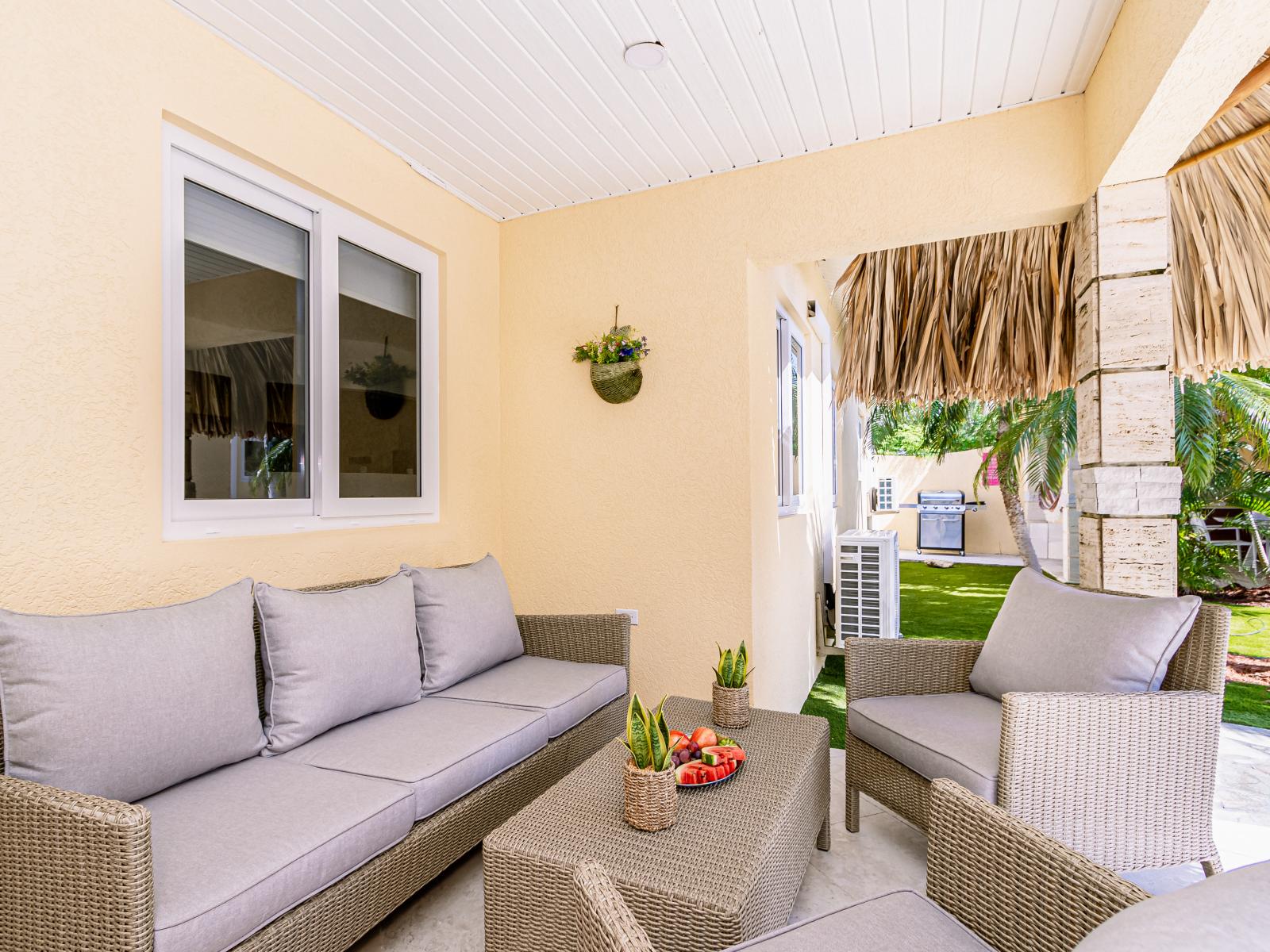 Fantastic outdoor sitting space of the Villa in Noord, Aruba - Beautiful Lawn facing sitting space - Elegant decor - Cosy sofas - Refreshing atmosphere - Soul relaxing space