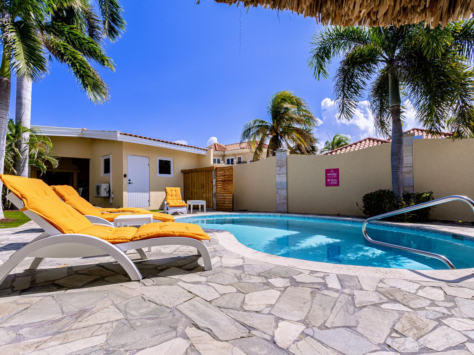 Enjoy the serene setting of our pool, shaded by swaying palm trees that evoke a sense of relaxation and paradise.