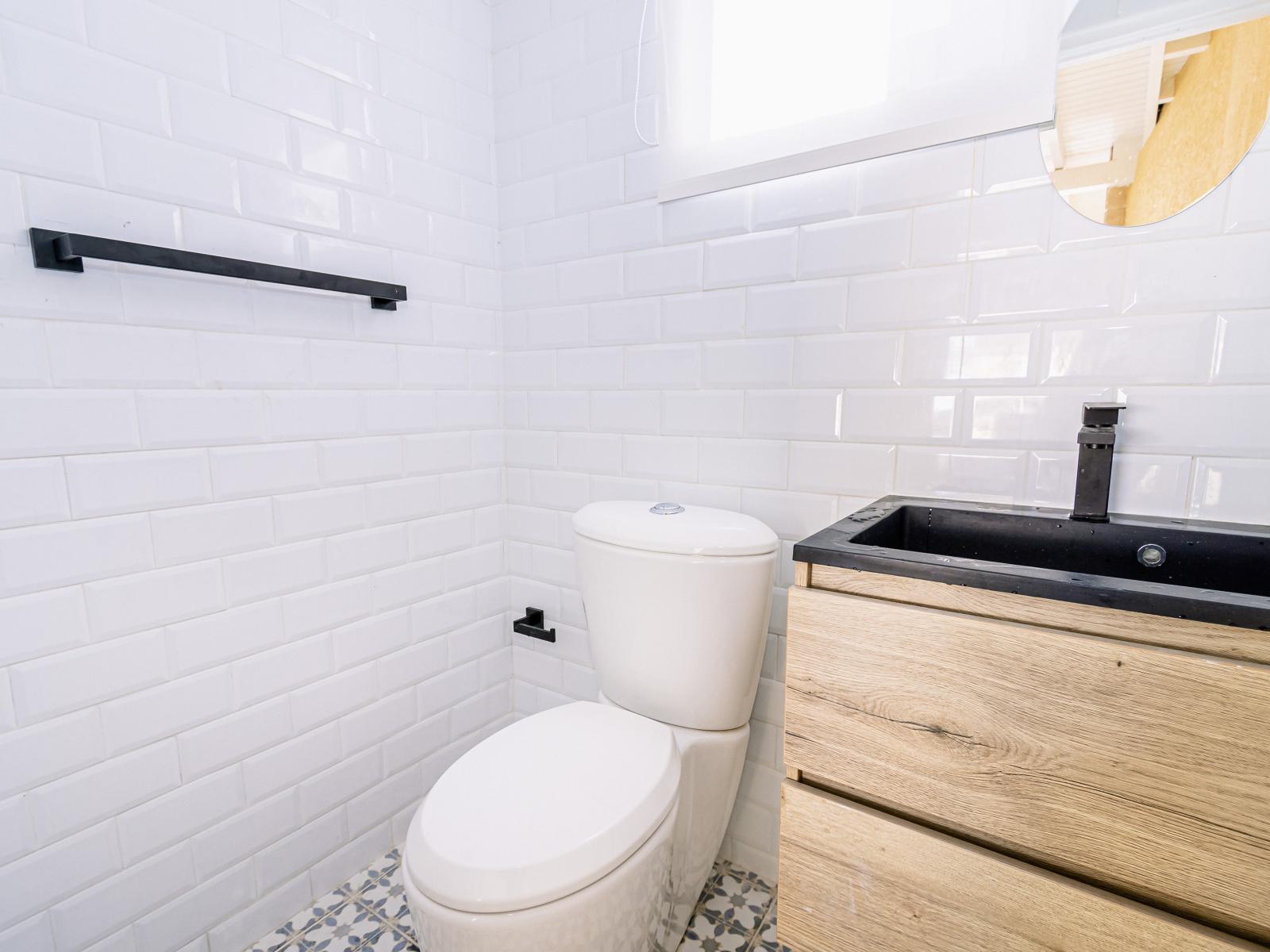 Convenience meets comfort in our half bathroom, featuring a sink and toilet for your convenience.