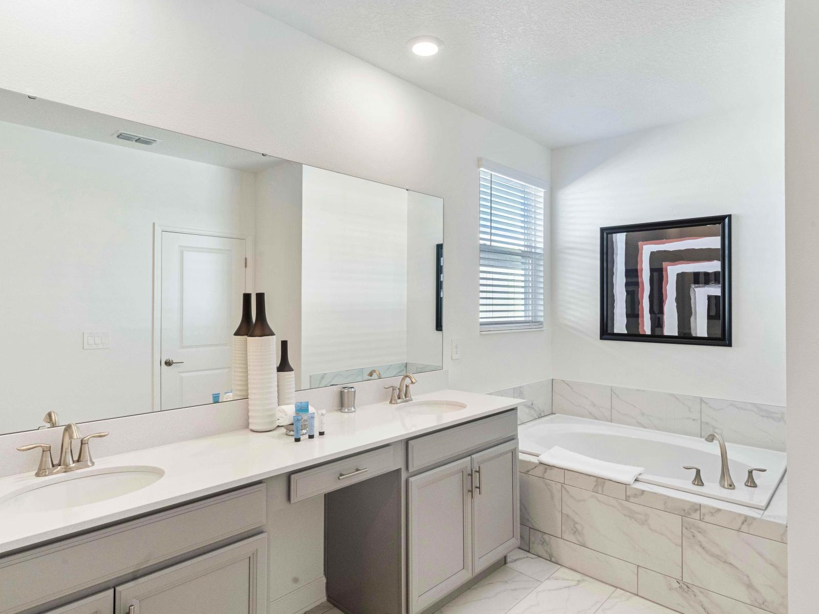 Clean Bathroom of the Townhouse in Davenport Florida - double Vanity, large mirrors and sophisticated bath tub - Elegant bathroom with luxurious fixtures and finishes