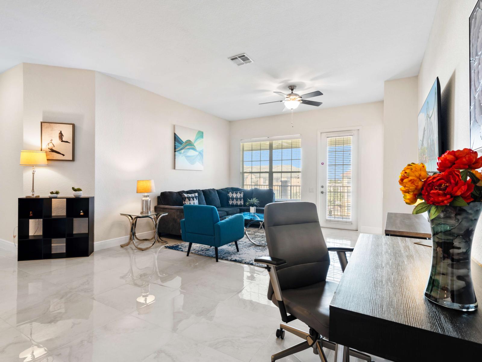 Living area with a large sofa, smart tv and ceiling fan