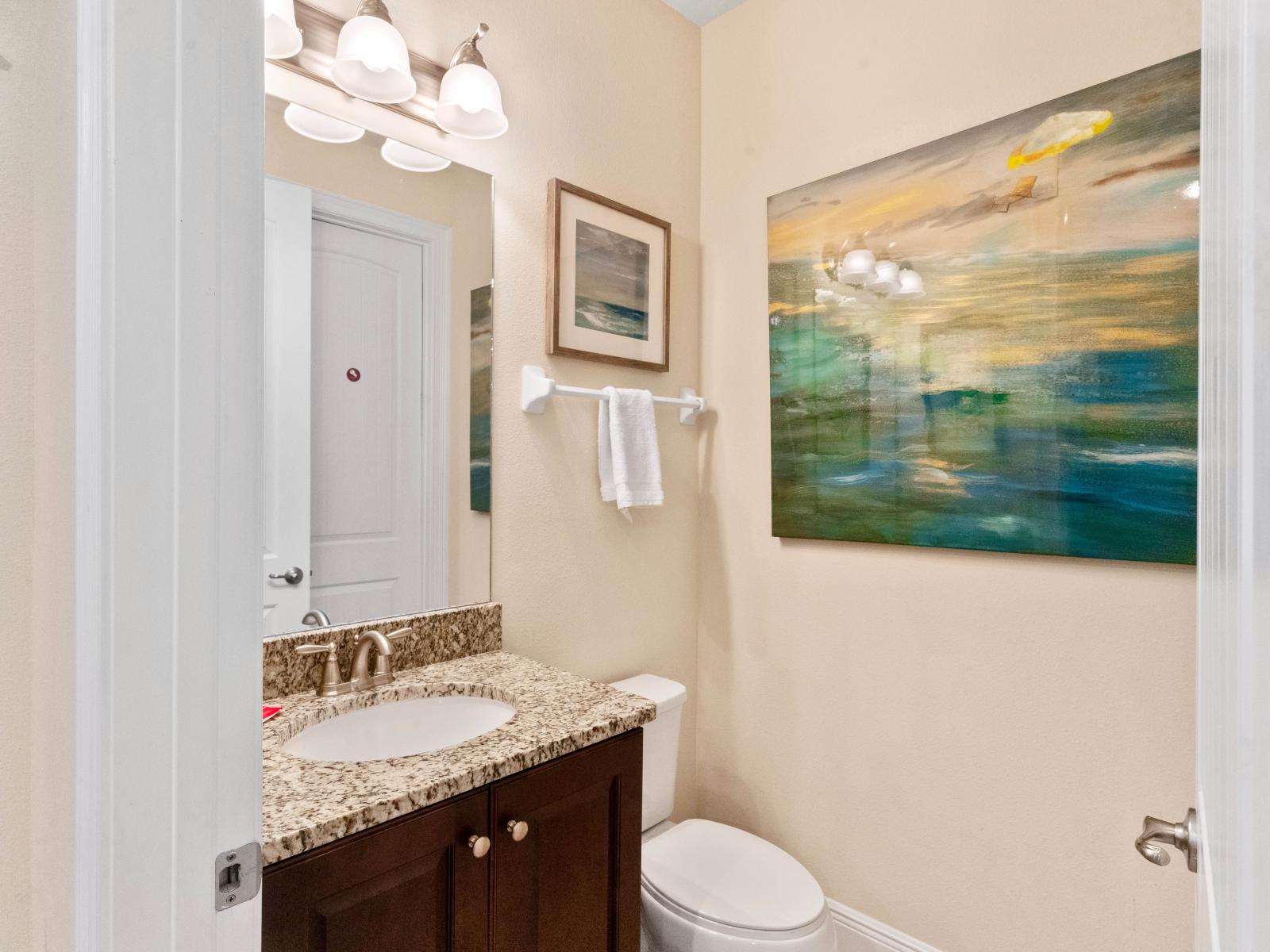 Elegant Powder Room of the Home in Kissimmee Florida - Embrace minimalist charm in our tastefully decorated powder room - Providing a serene space for relaxation with chic vanity and large mirror - Clean toilet seat and upscale lighting