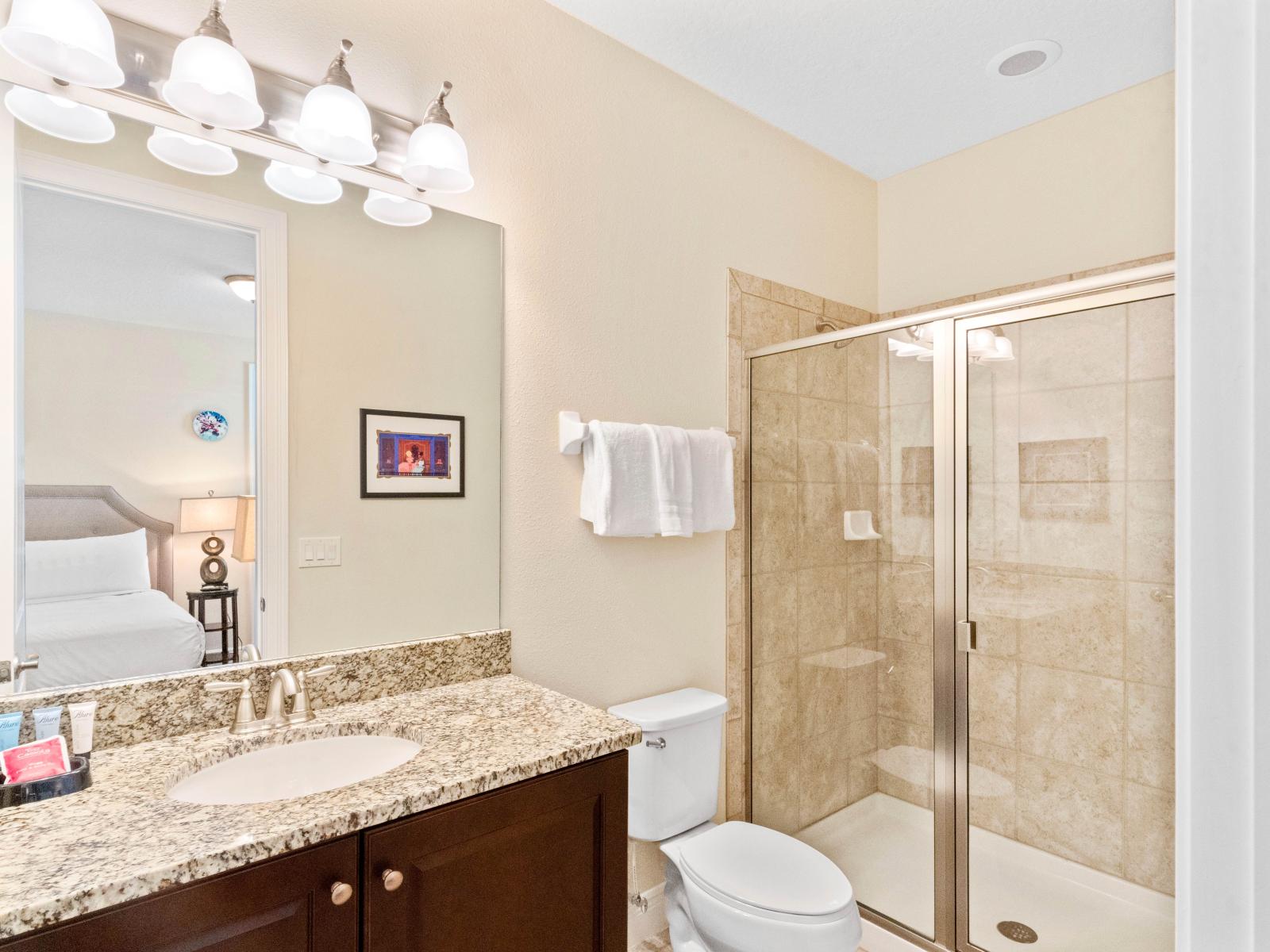 Refined Bathroom of the Home in Kissimmee Florida - Featuring upscale finishes and luxurious fixtures - Glass-enclosed shower area - Lush vanity with upscale lighting