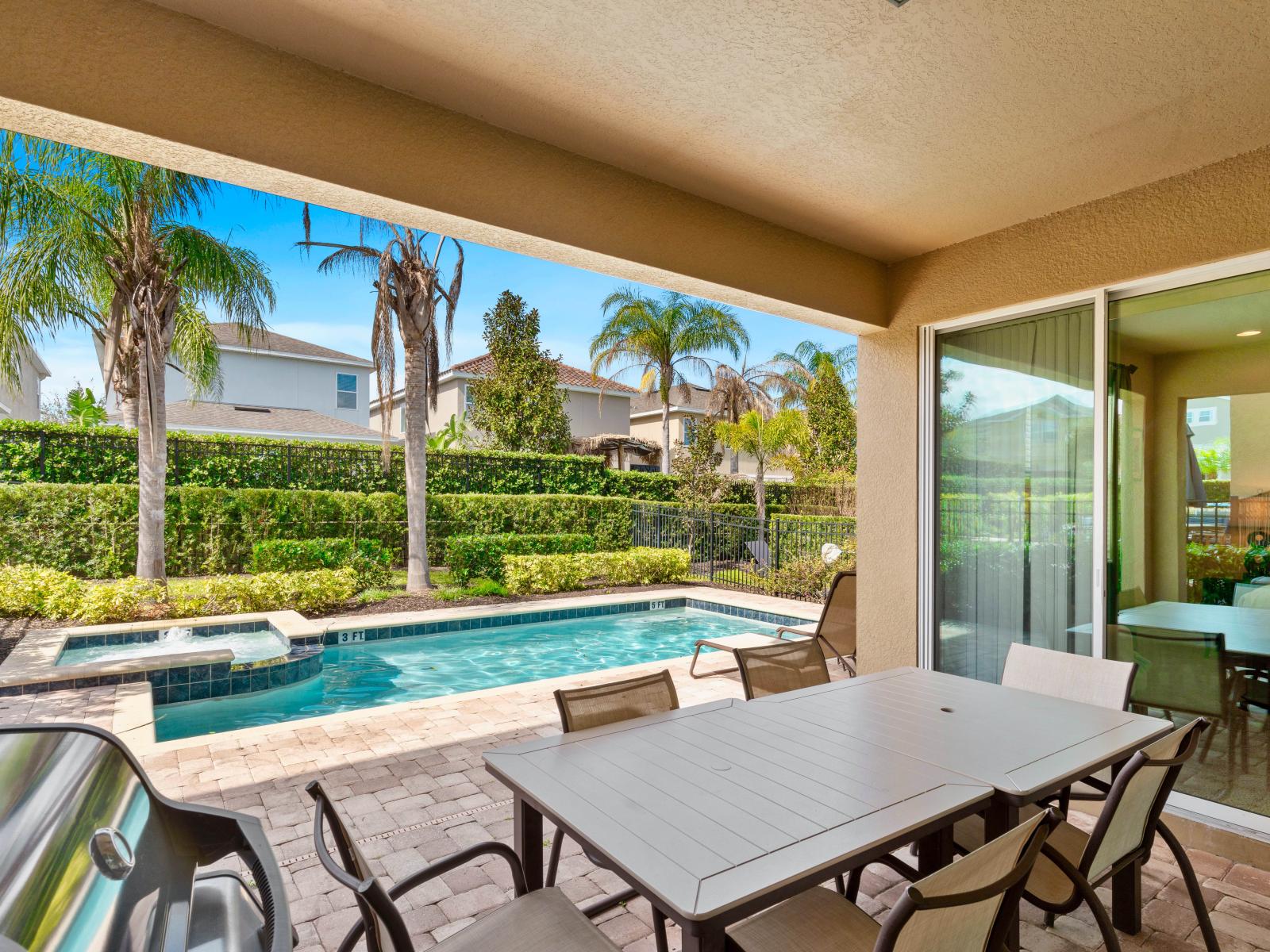 Alfresco Dining Area of the Home in Kissimmee Florida - Shaded Patio Table and BBQ for Outdoor Delights  - Stunning Pool Views - Refreshing Atmosphere