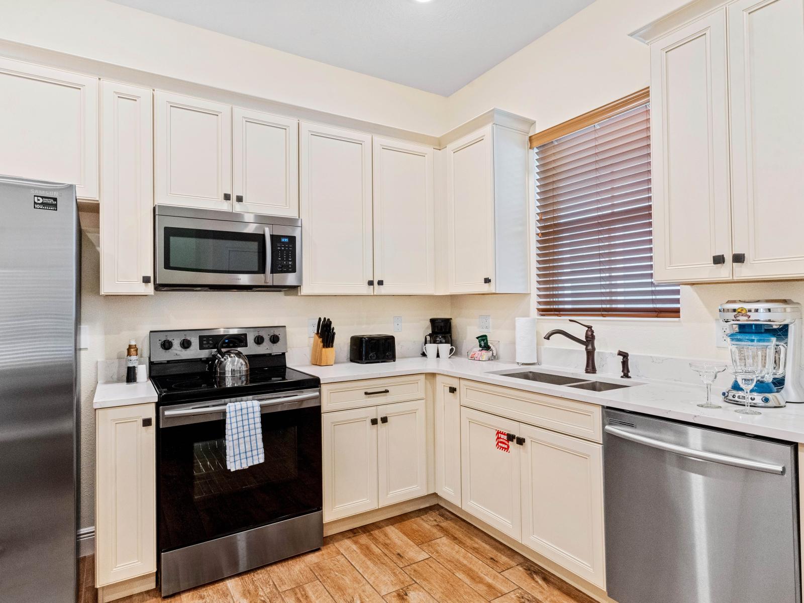 Experience Culinary Comfort: This Fully Functional Kitchen Offers Gorgeous Countertops, Pristine Cabinetry, and Deluxe Stainless-Steel Appliances for Effortless Feasting.