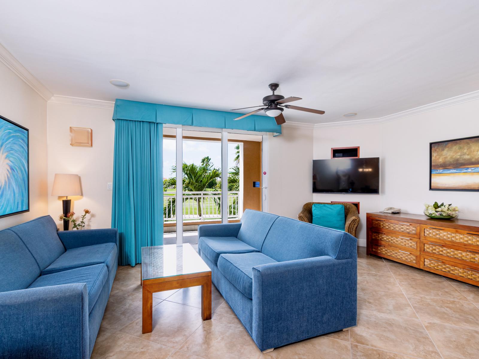 Sublime living area of the condo in Noord Aruba - Cosy sofas - Beautifully located large windows of the villa with mesmerizing views - Elite ambiance - Beautifully decored with wall paintings - Availability of TV and Netflix