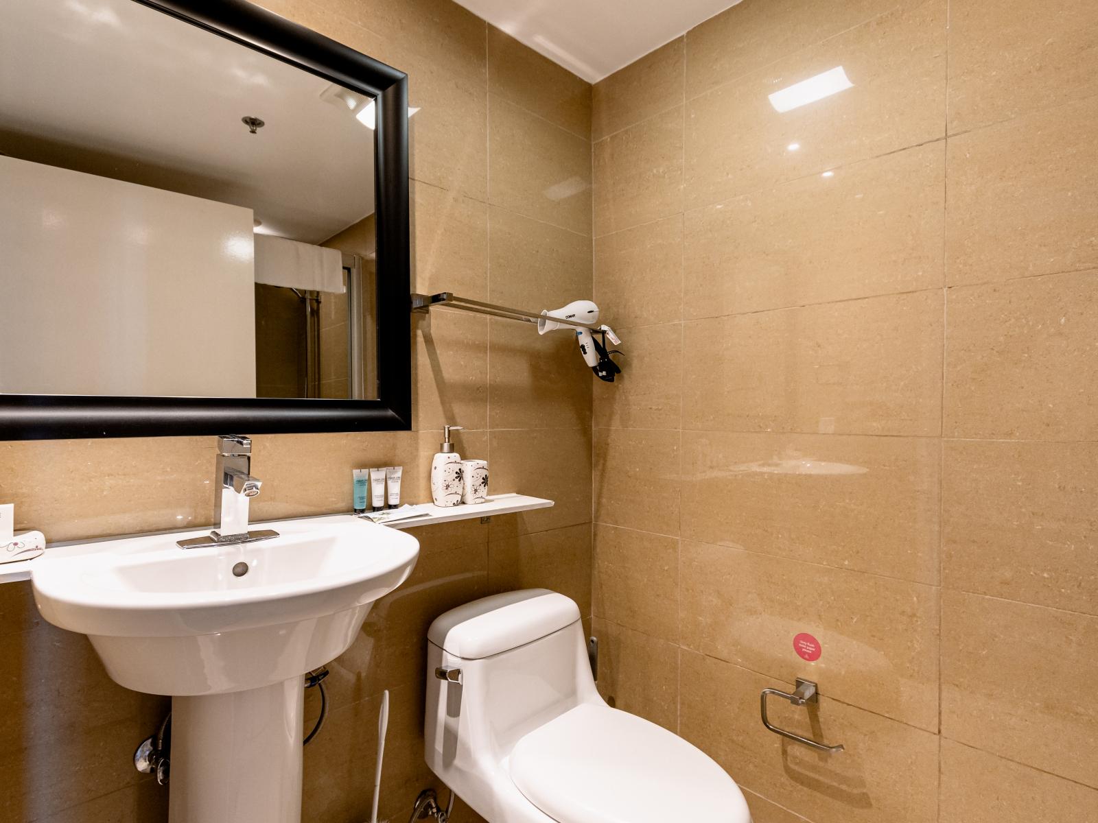 Deluxe Bathroom of the condo in Noord Aruba - Chic design featuring a sleek vanity and upscale lighting - Seamless design featuring a glass-enclosed shower - Spacious layout offering a sense of luxury and comfort