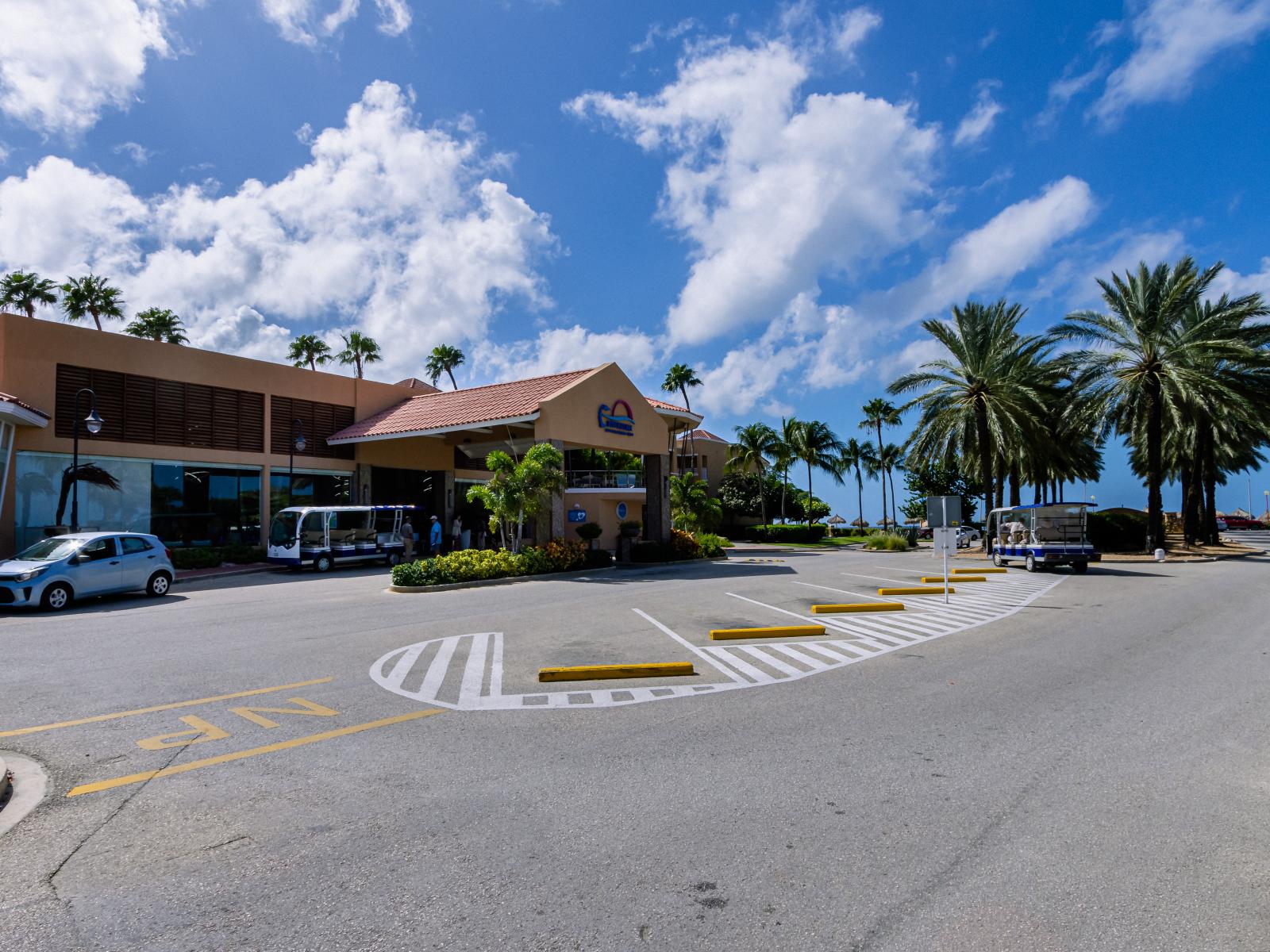 Divi Villa Lobby entrance in Noord Aruba - Quite Neighborhood - A picturesque street adorned with lush greenery - A unique building with innovative and elegant architecture - Stunning Surroundings