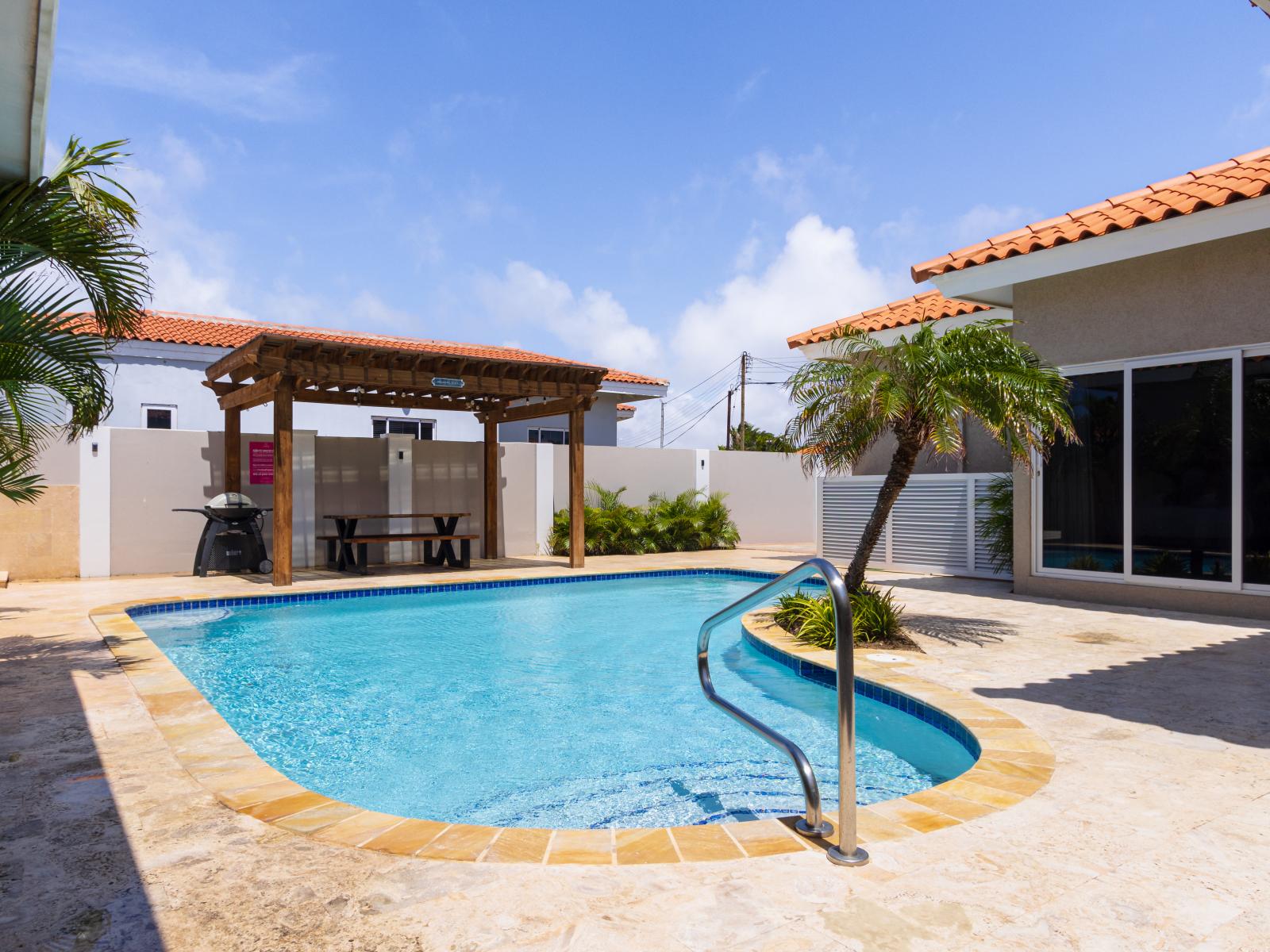 Luxury pool area of the apartment in Noord, Aruba - Lush and refreshing environment - Cozy beach chairs available - Beautifully sunbathed space makes the soul peaceful - Experience the comfort at the best
