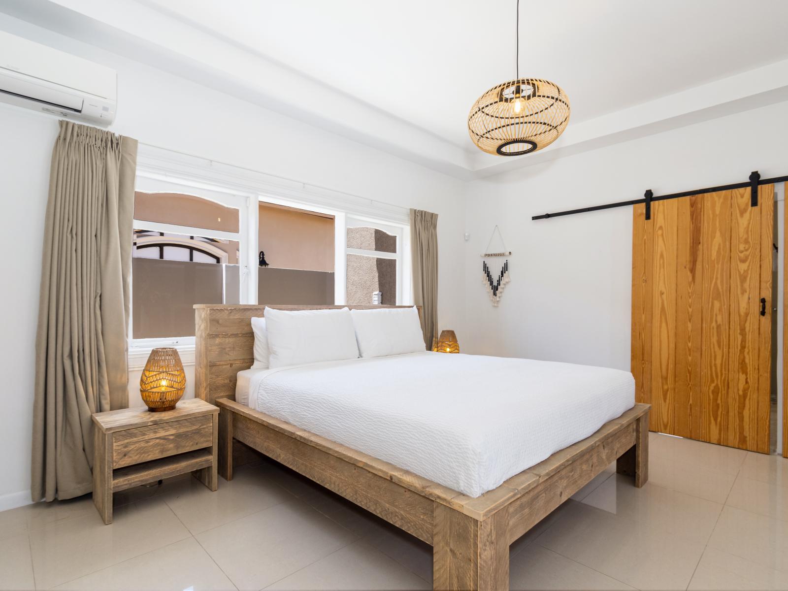Imposing Bedroom of the Apartment in Noord Aruba - Smart TV and Netflix - Cozy retreat with a plush bed, perfect for relaxation - Minimalist decor, creating a clean and uncluttered sleeping space