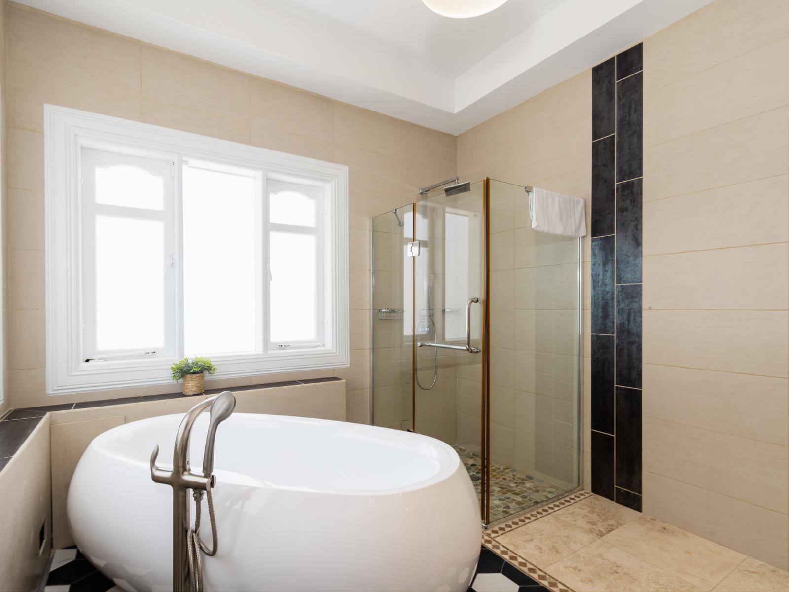 Stylish Bathroom of the Apartment in Noord Aruba - Glass-enclosed shower area - Spa-like atmosphere with a modern, superb bathtub - Elegant bathroom with luxurious fixtures and finishes