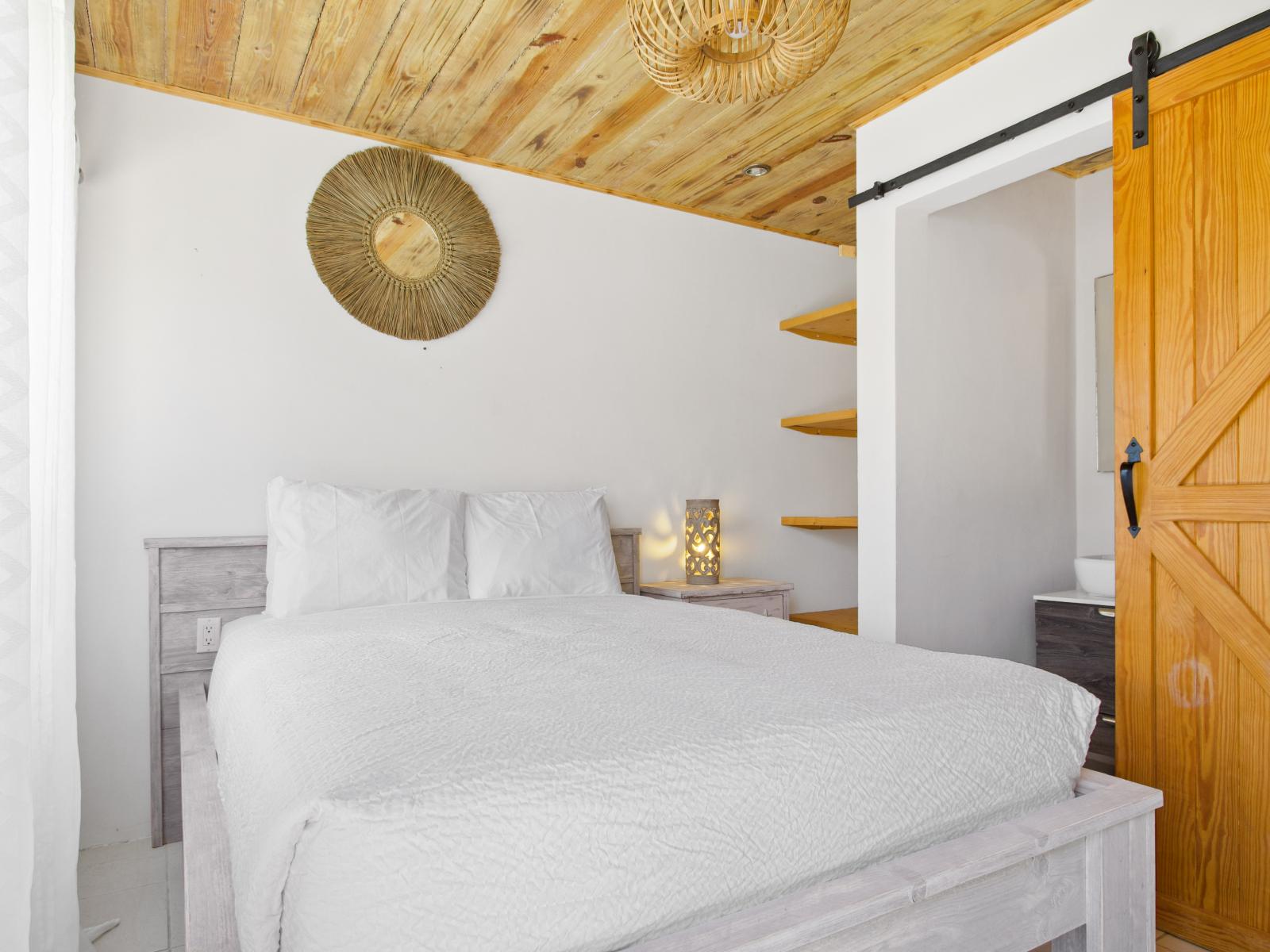 Lofty Bedroom of the Apartment in Nrood Aruba - Cozy retreat with a plush bed, perfect for relaxation - Bright and airy bedroom with large windows for natural illumination - Modern and stylish decor that complements the space
