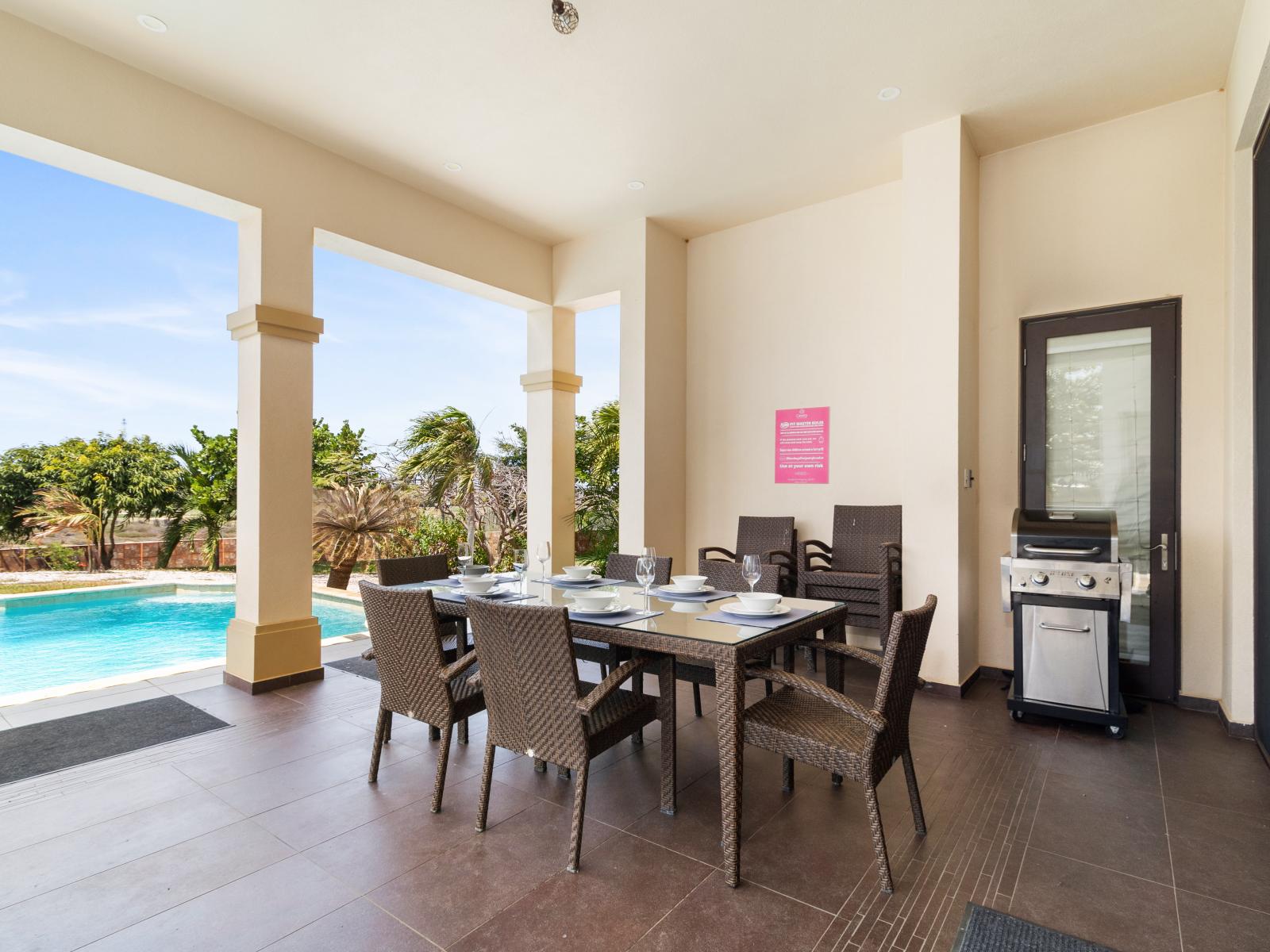 Outside dining table located next to the sliding doors that lead into the villa