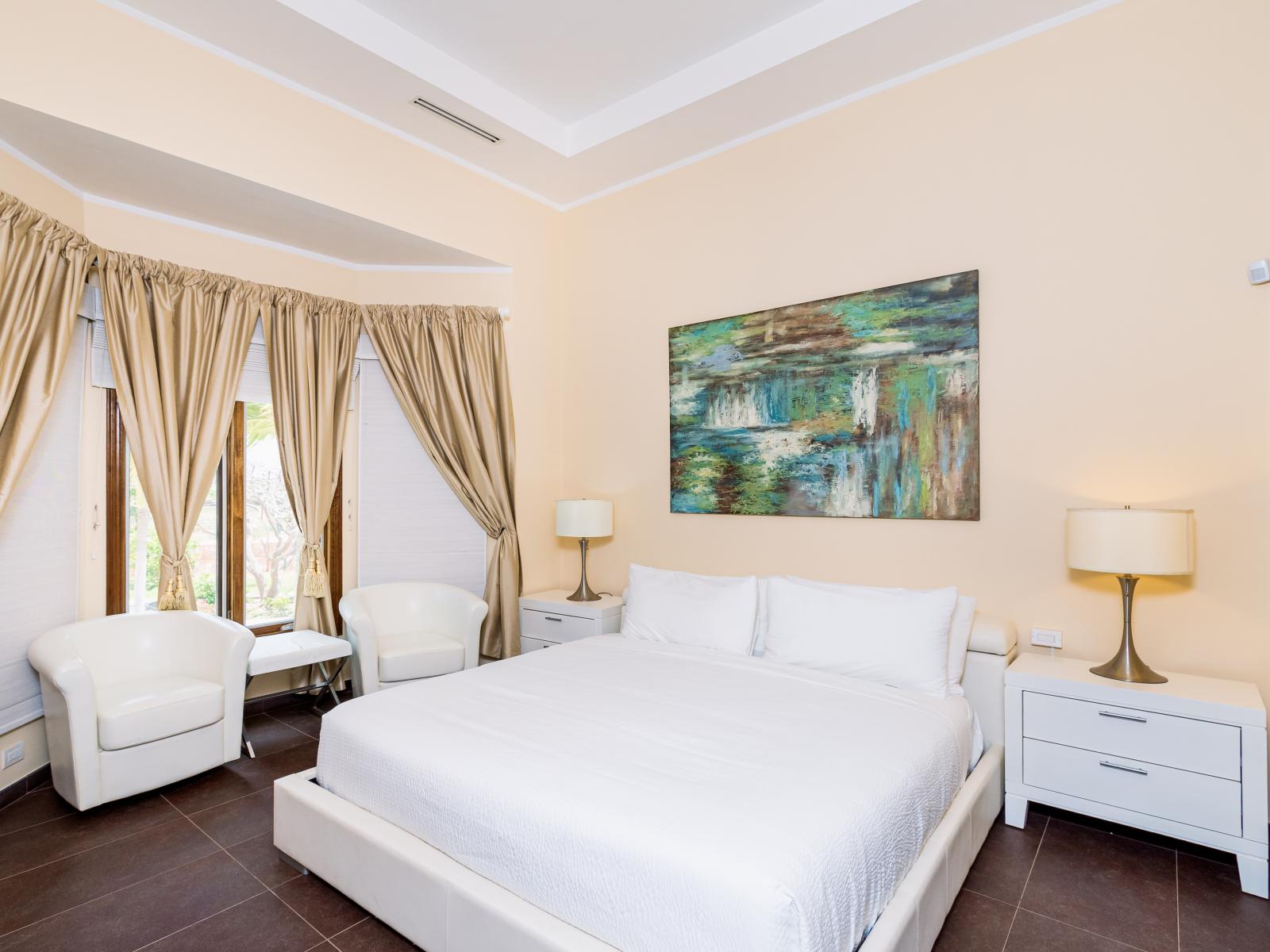 Experience unparalleled comfort in Bedroom 2 with a regal King bed, wall-mounted TV, and the luxury of an attached bathroom, offering a personal haven for seamless relaxation with modern amenities.