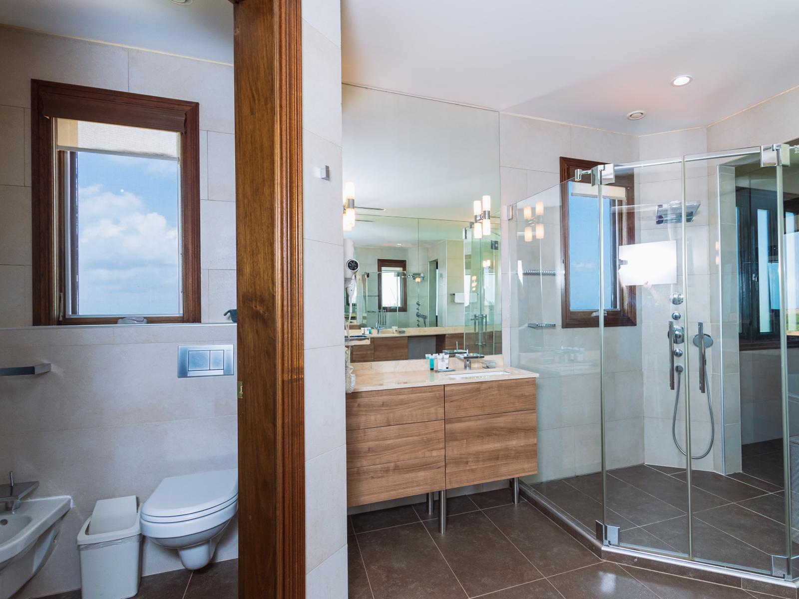 Experience modern luxury in Bathroom 3, boasting a sleek walk-in shower for your convenience. Step into this elegant space and indulge in a refreshing rinse, ensuring every moment of your stay is infused with comfort and style.