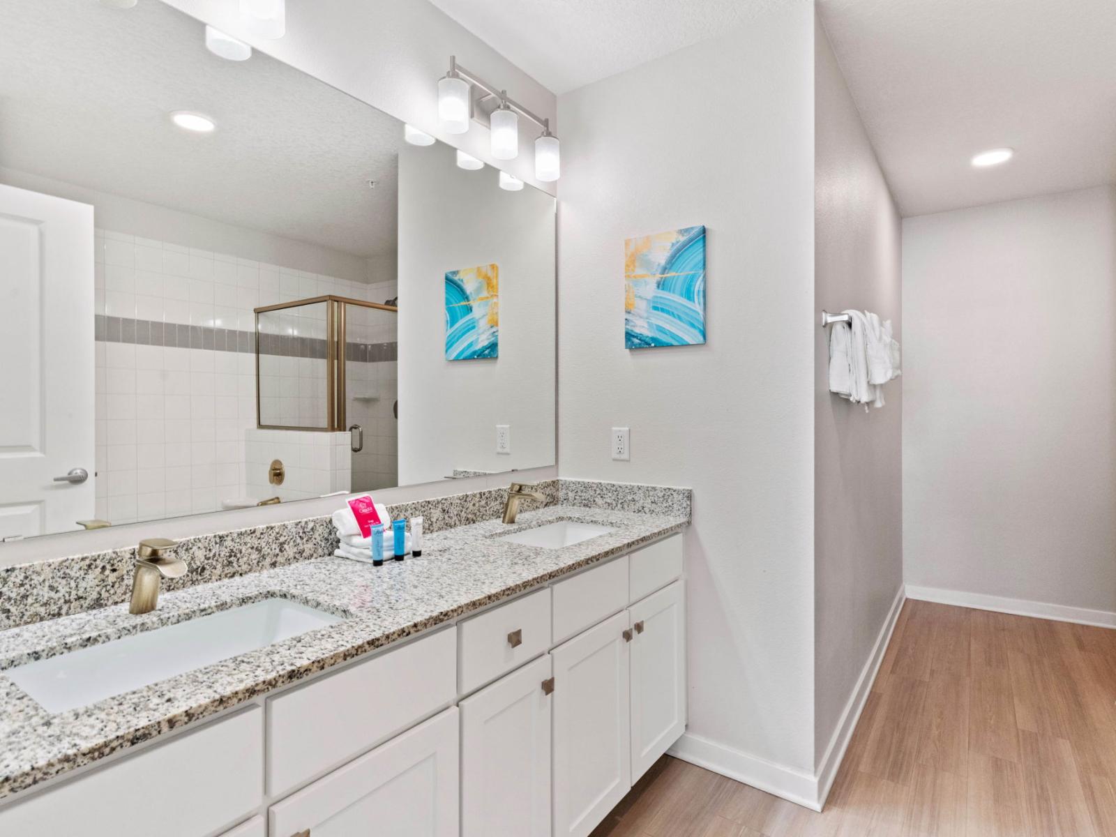 Immerse yourself in the modern elegance of our luxury bathroom of the condo at Vista Cay Resort - Revel in the sleek sophistication of our bathroom with Glorious twin sink Vanity with large wall mirror  - Stunningly designed glass cabin shower area