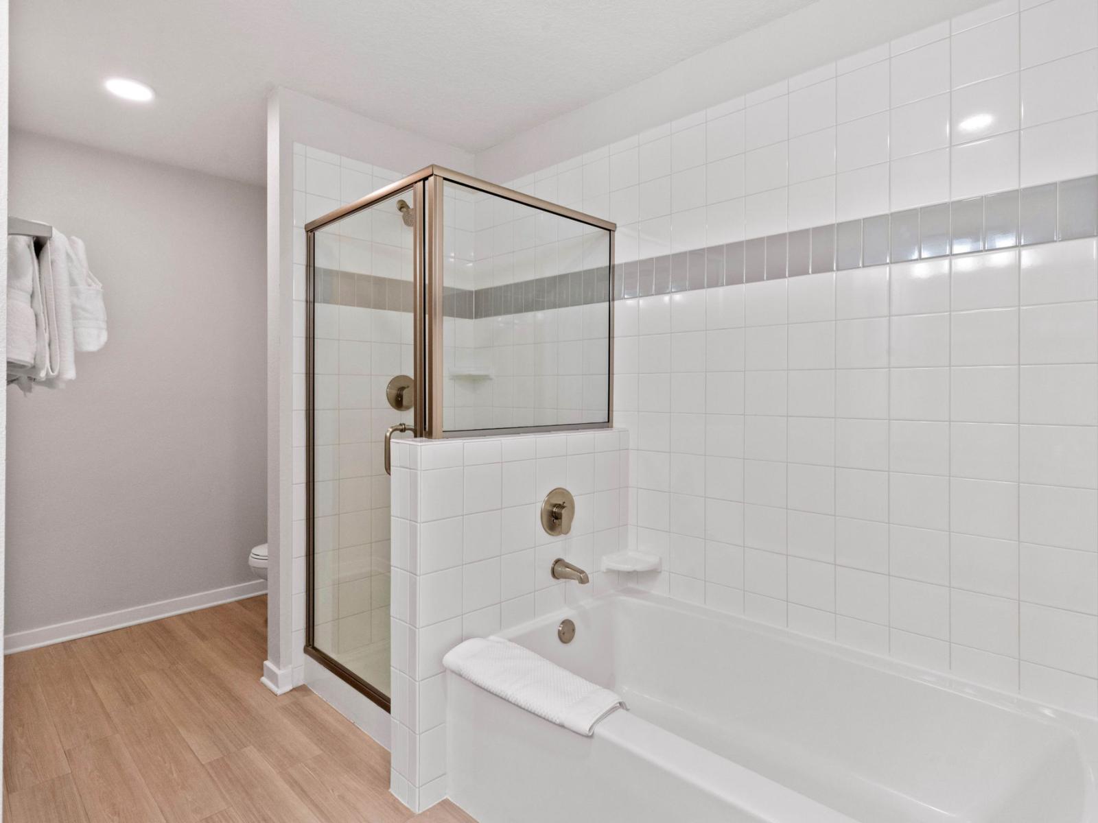 Stunning and cozy bathtub and shower area in the main bathroom of the condo at Vista Cay Resort  - Gloriously tile furnished bathroom - Neat and fresh towels available - Wooden furnished floor - Elegant lighting