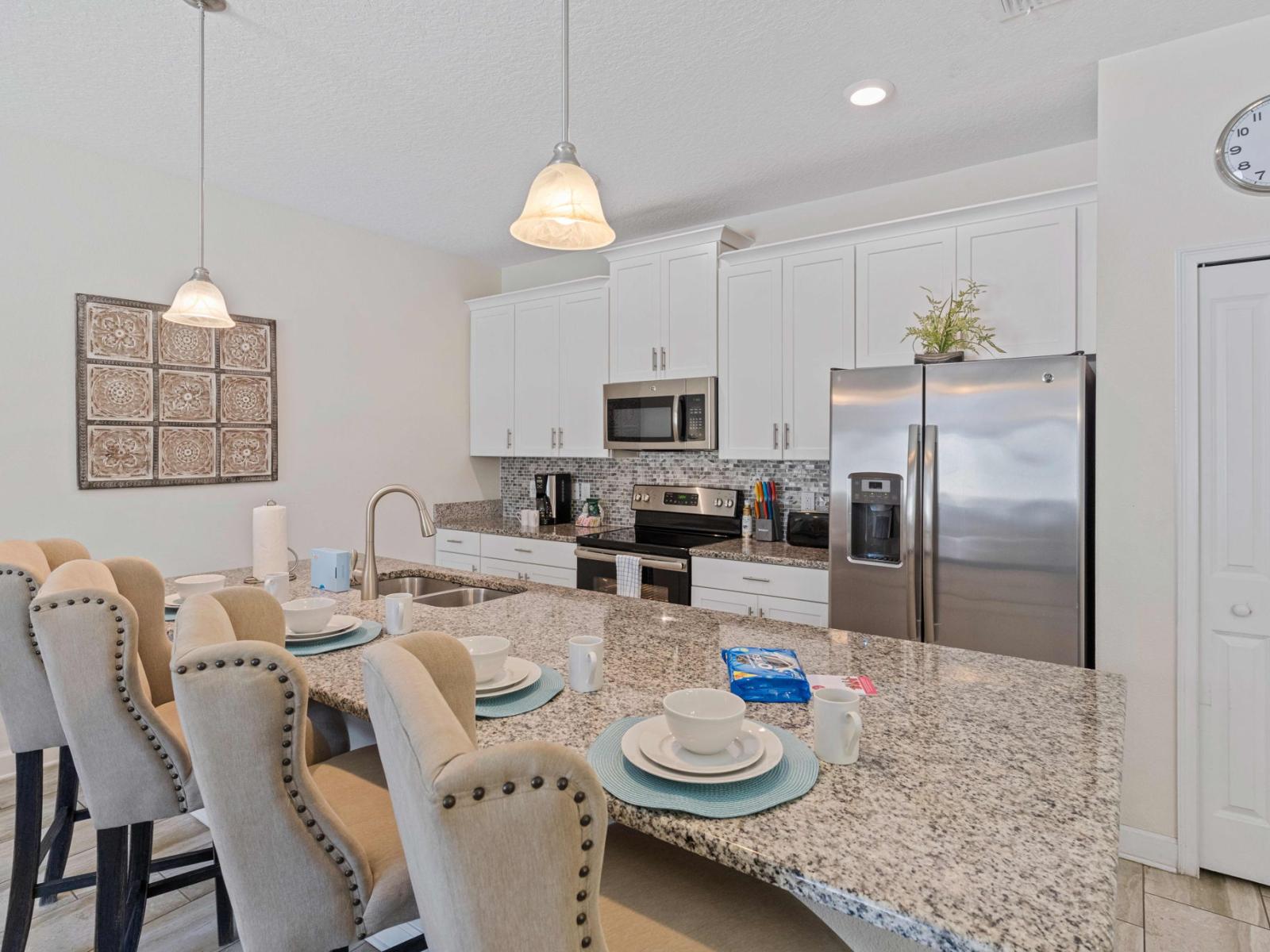 Sleek kitchen of the town house in Kissimmee Florida - Breakfast bar and high chairs - Integrated appliances for a seamless and stylish appearance - Thoughtful placement of kitchen essentials for easy access