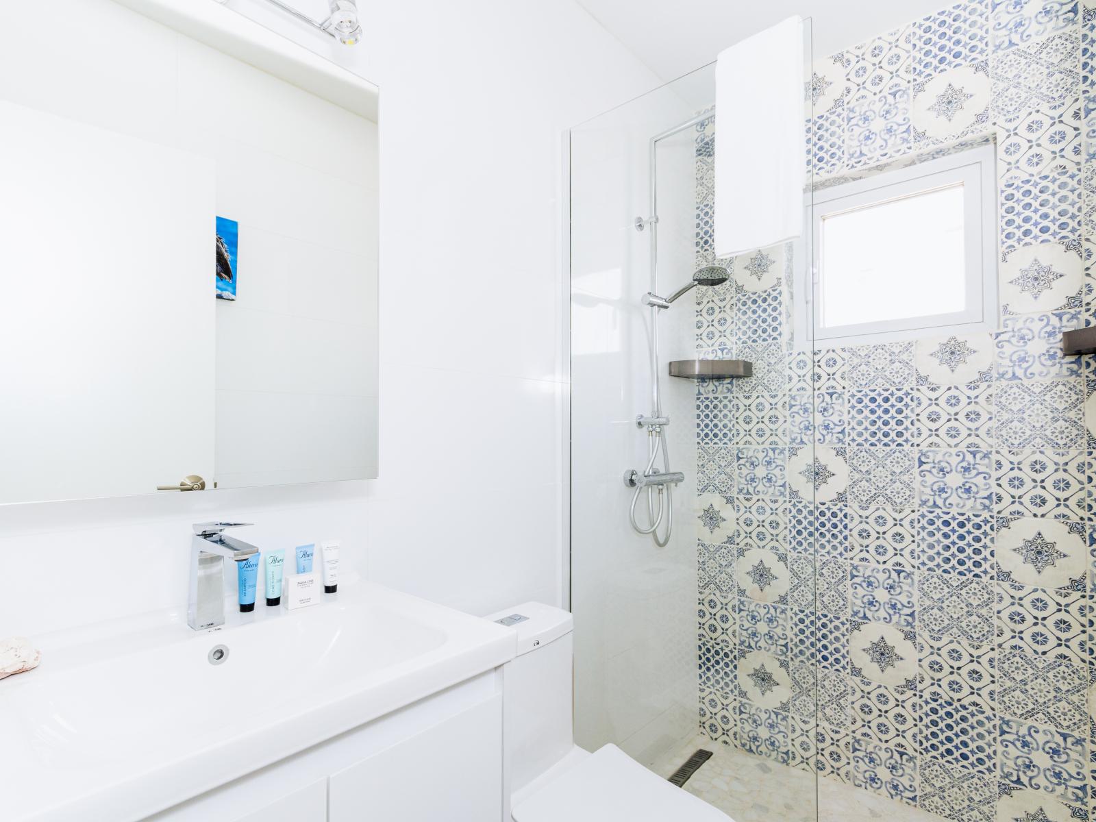 Indulge in luxury: Bathroom 3 features a stylish vanity, a modern toilet, and a spacious walk-in shower, offering a refreshing sanctuary where you can pamper yourself in comfort and style.