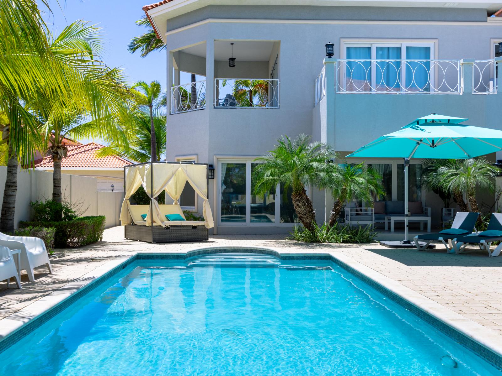 Glorious pool area of the villa in Aruba - Cosy beach chairs and neat and clean towels available - Beautiful views - Superbly designed pool area with umbrella shades - Refreshing Environment - Vibrant Atmosphere