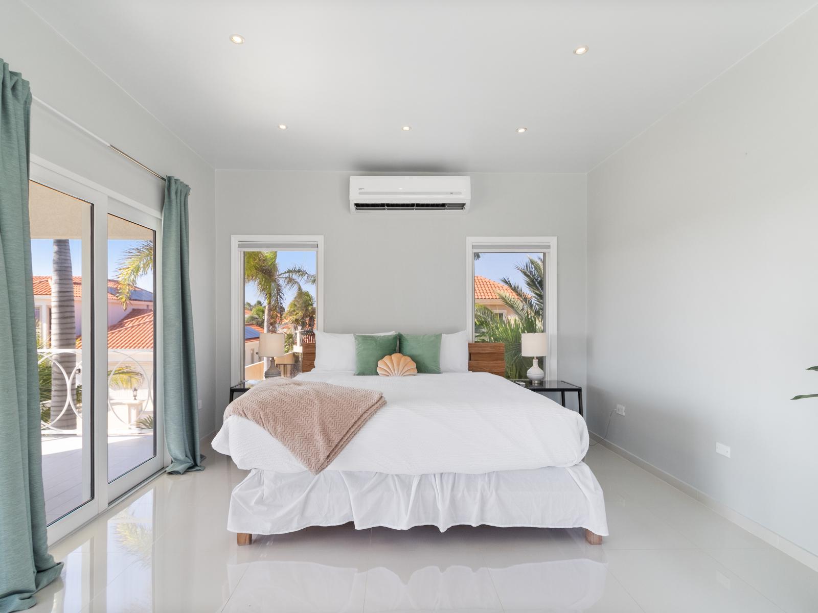 Spacious bedroom of the villa in Noord Aruba - Comfy King bed - Elegantly designed room - Beautiful painted walls with decoration - Majestic table lamps - Neat and clean linen - Large windows with beautiful views - TV and Netflix available