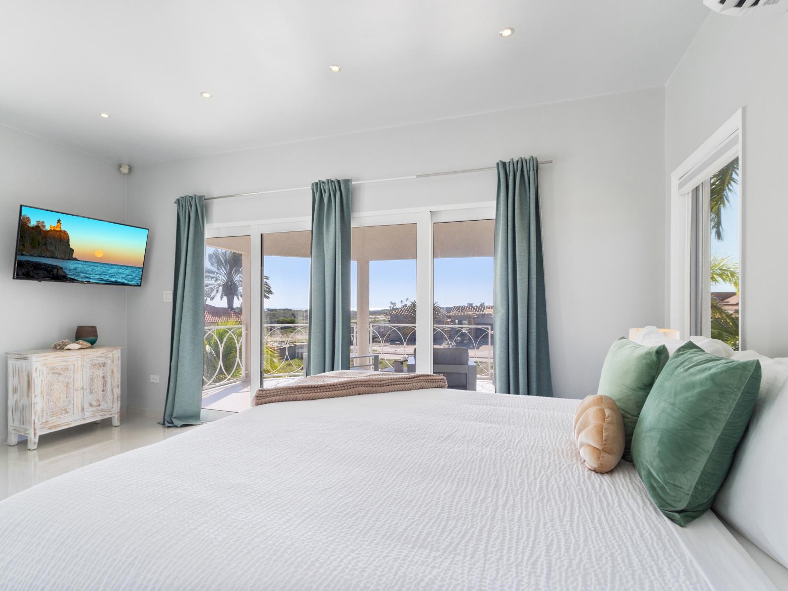 Panoramic bedroom of the villa in Noord Aruba - Comfy King bed - Elegantly designed room - Beautiful painted walls with decoration - Majestic table lamps - Neat and clean linen - Large windows with beautiful views - TV and Netflix available