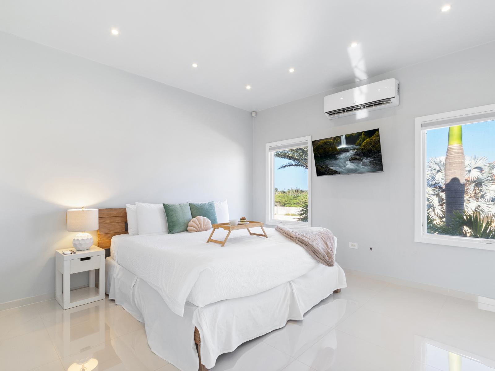 Imposing bedroom of the villa in Aruba - Cosy king size bed - Elegantly designed room - Bright and airy space with superb lighting - Beautiful marble furnished floor - Majestic windows with elite views - Availability of TV and Netflix