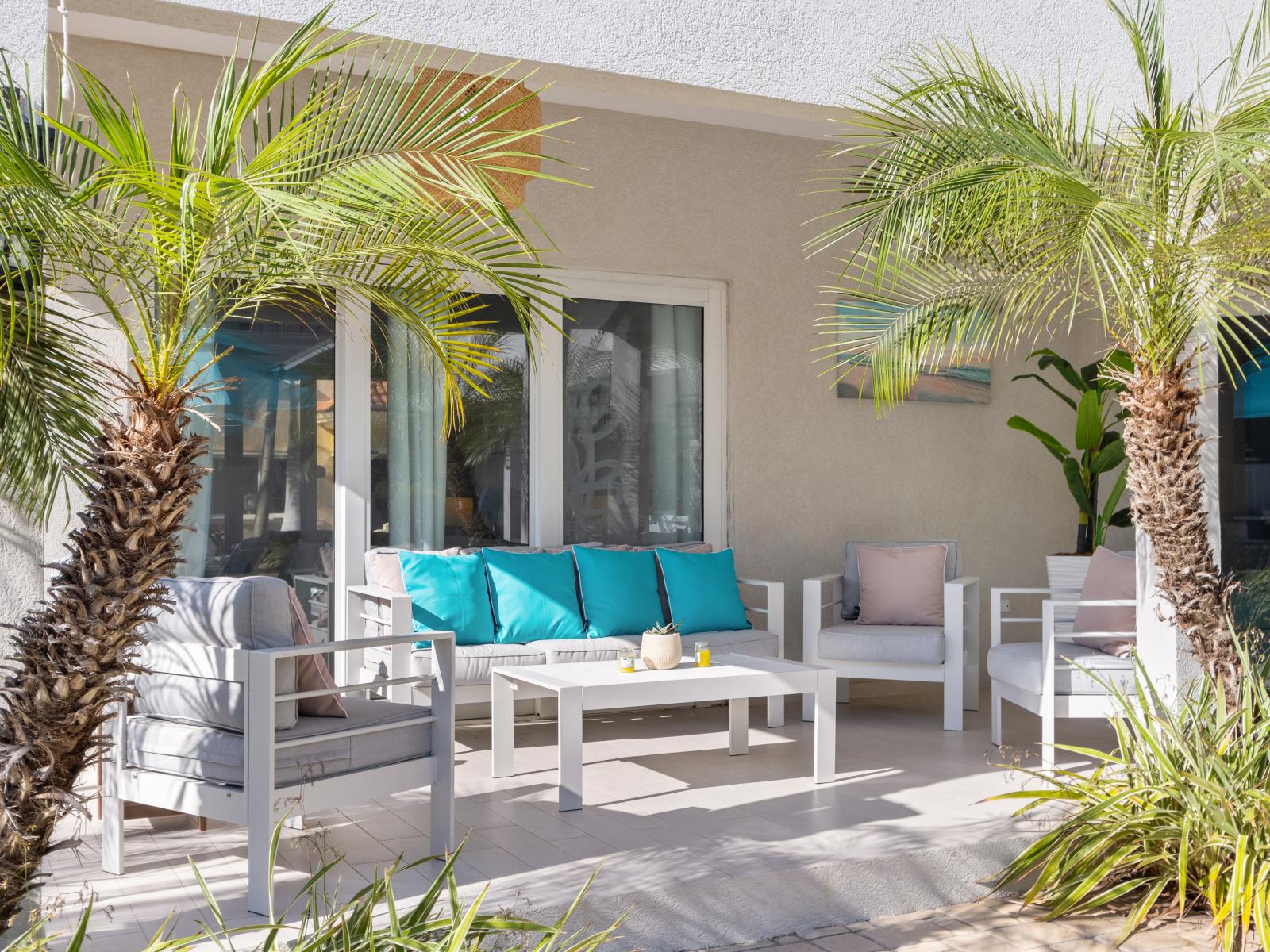 Lush outdoor Seating Area of the villa in Noord Aruba - Perfect Spot for Pictures - Refreshing Atmosphere - Beautifully painted wall - Magnificently decored with refreshing plants pots