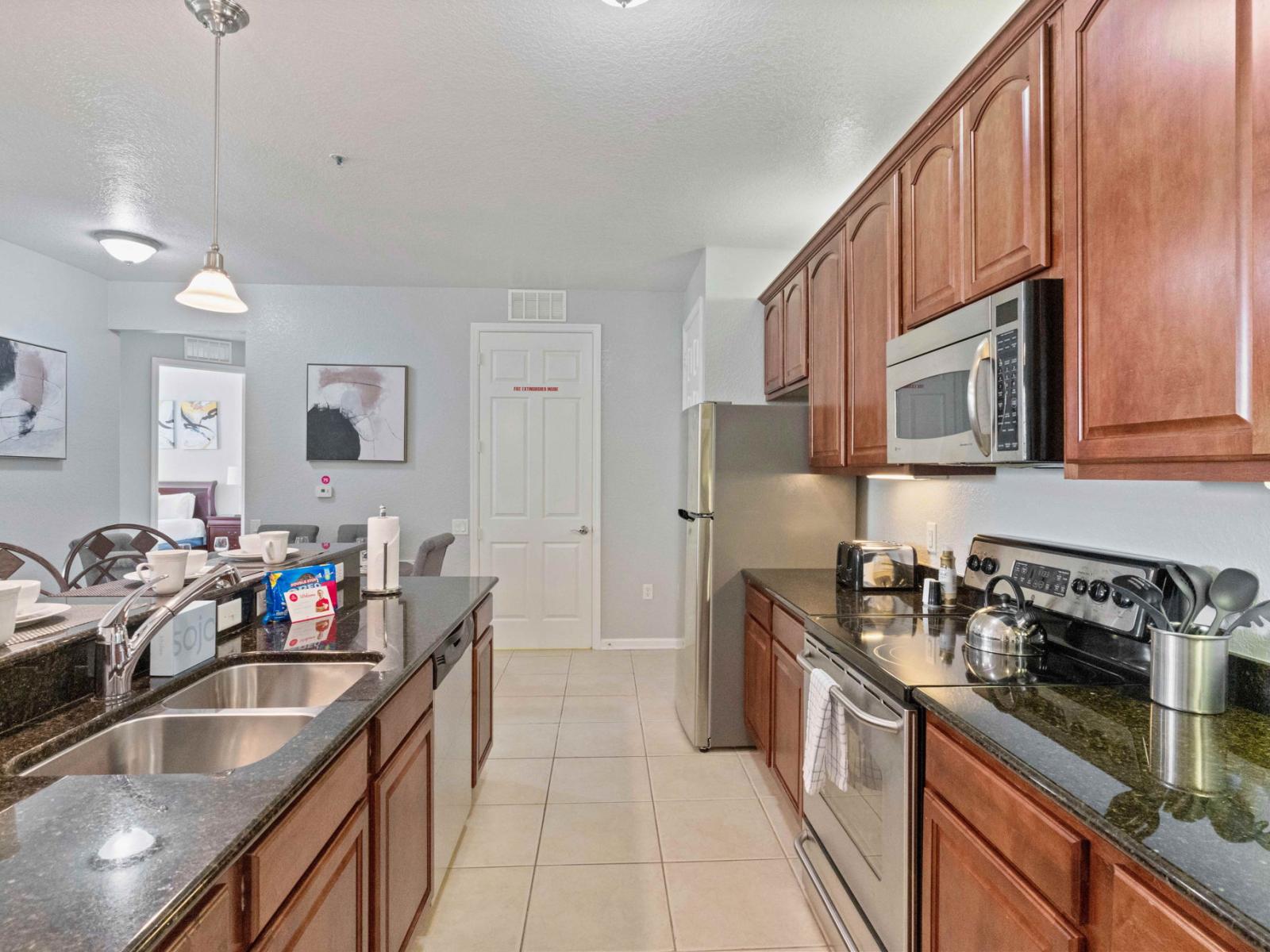 Modern Kitchen of the condo in Orlando - Fully equipped with all kitchen accessories - Stainless steel appliances available - Sufficient storage space in beautiful wooden cupboards