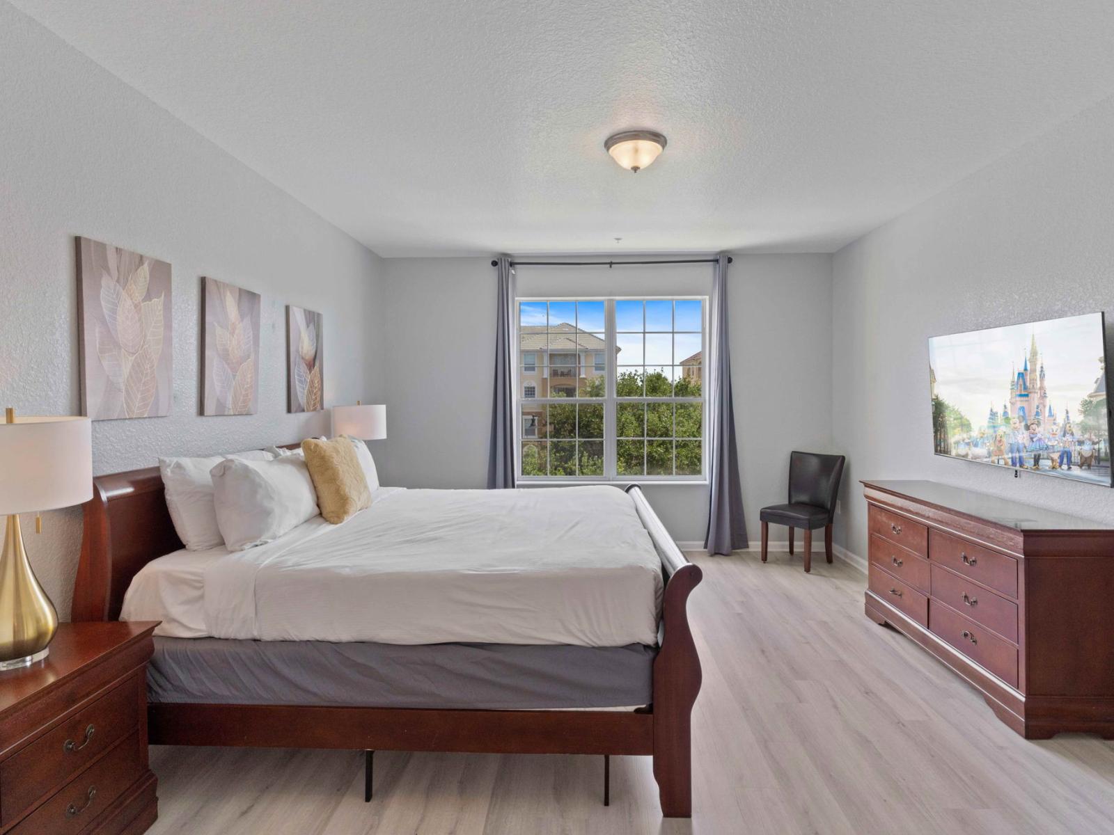 Majestic bedroom of the condo in Orlando - A comfy chair and smart TV for entertainment - Spacious bedroom offering comfort and style - Cozy double bed - Stunning views from the bedroom window