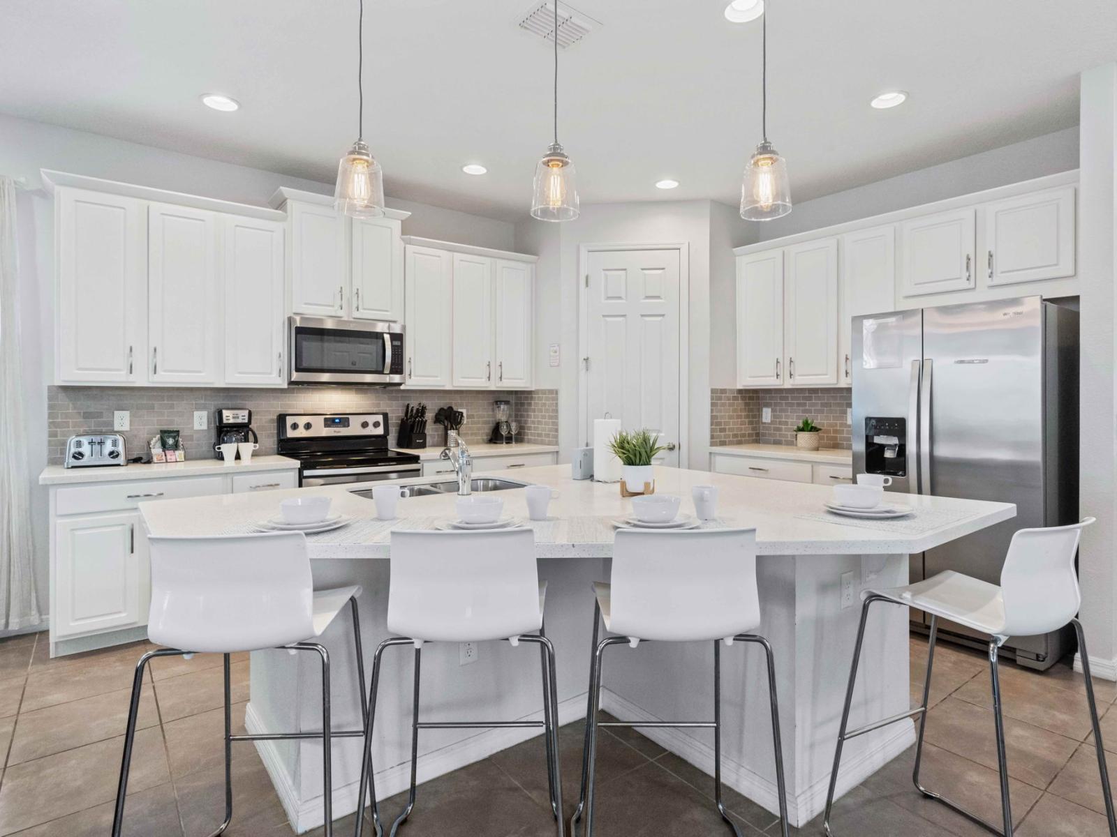 Modern kitchen of the home in Kissimmee Florida - Countertop table with high chairs - Where you can quickly grab a snack or drink your coffee and tea - Contemporary design with clean lines and minimalist aesthetics - Stainless steel appliances