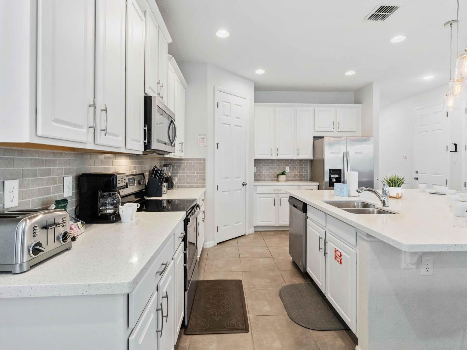 Fully equipped kitchen featuring a spacious countertop table, providing ample room for preparing meals with ease and convenience.