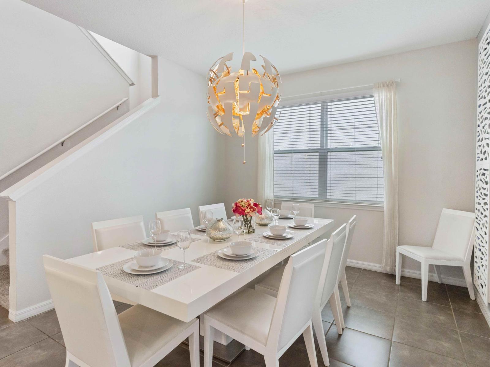 Swish dining area of the home in Kissimmee Florida - An eight seater dining table  - An extra chair for a more comfortable space - Statement chandelier - Quality materials, such as a sleek dining table and comfortable chairs