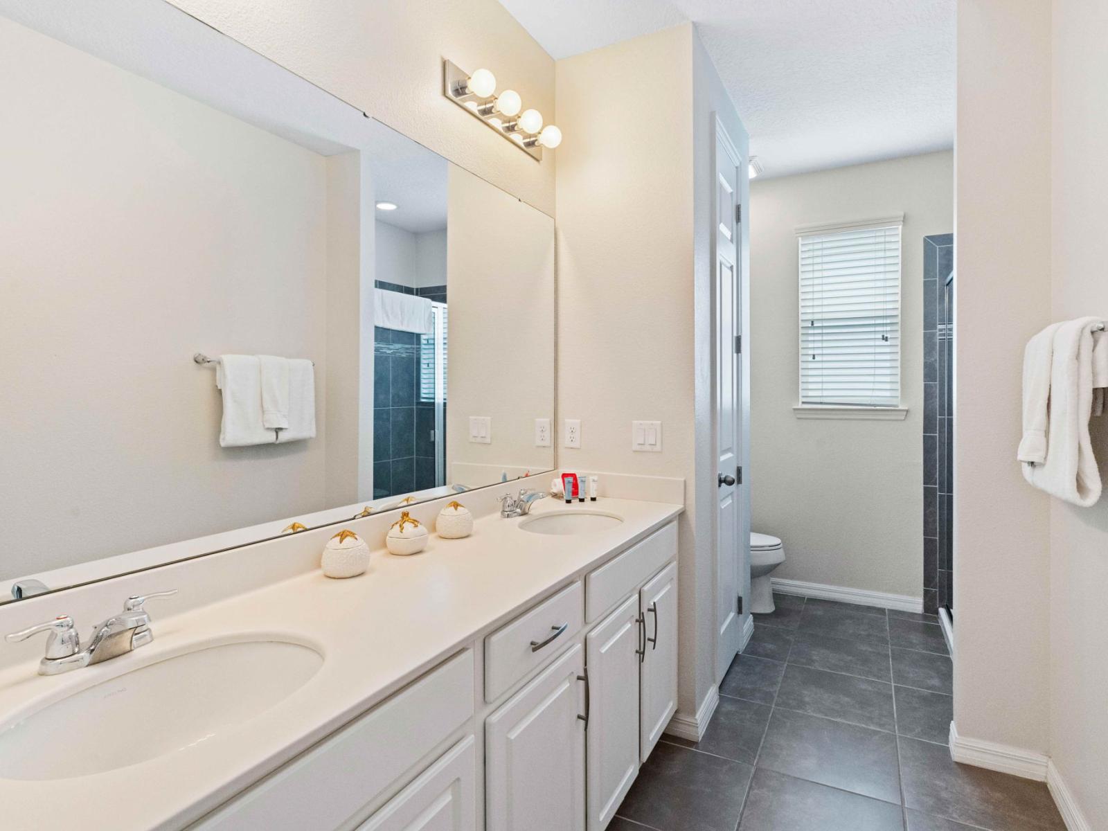 Sleek bathroom  of the home in Kissimmee Florida - Discover the pinnacle of tranquility in comfy bathroom - Complete with a luxurious dual vanity with large mirror - Sleek walk-in shower for a spa-inspired retreat