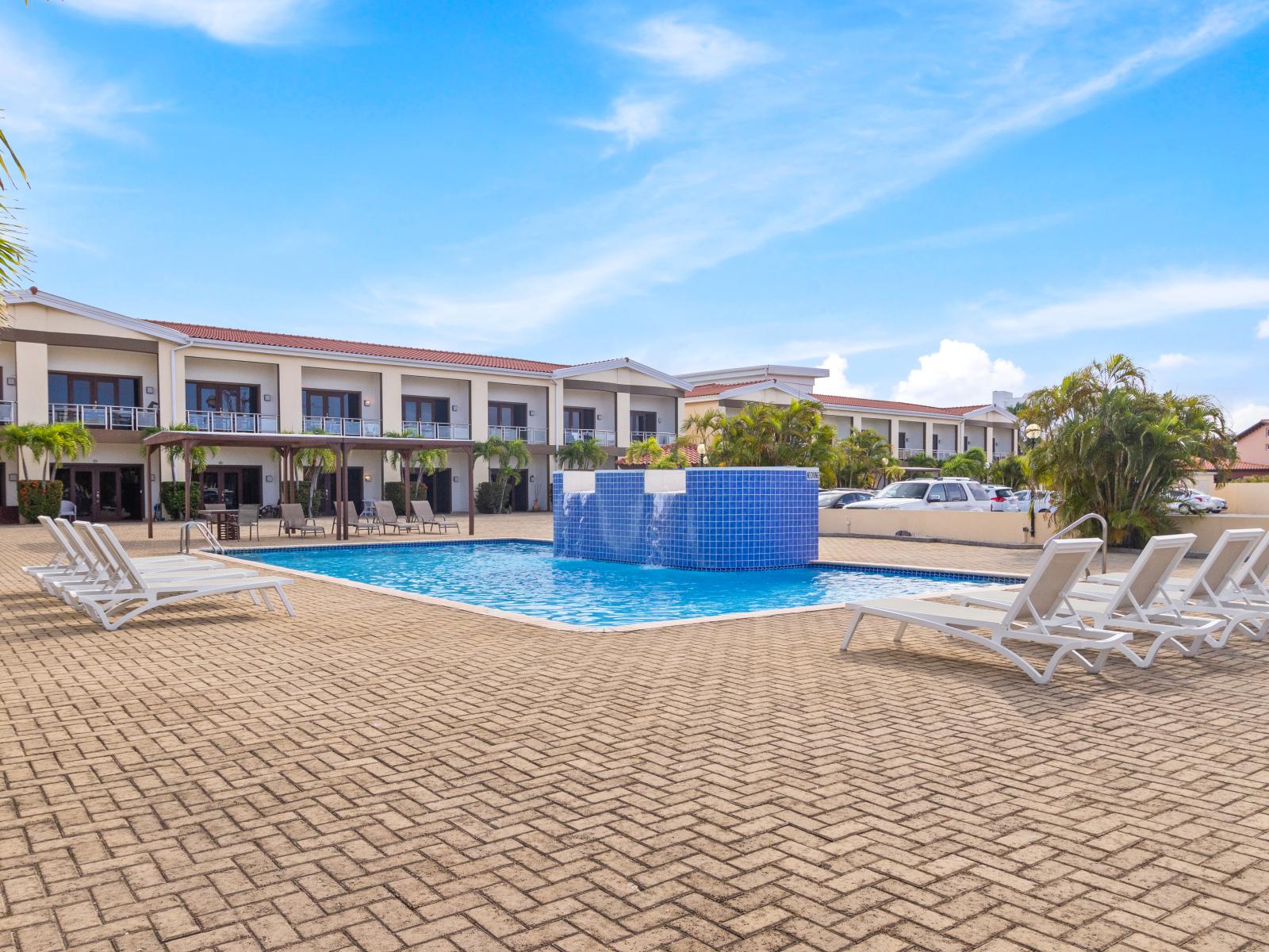 Splendid Pool Area of the 2BR Condo in Noord Aruba - Poolside Lounge Area with many seating options - Transforms into a serene setting with poolside - A spot for friends and family to gather and socialize