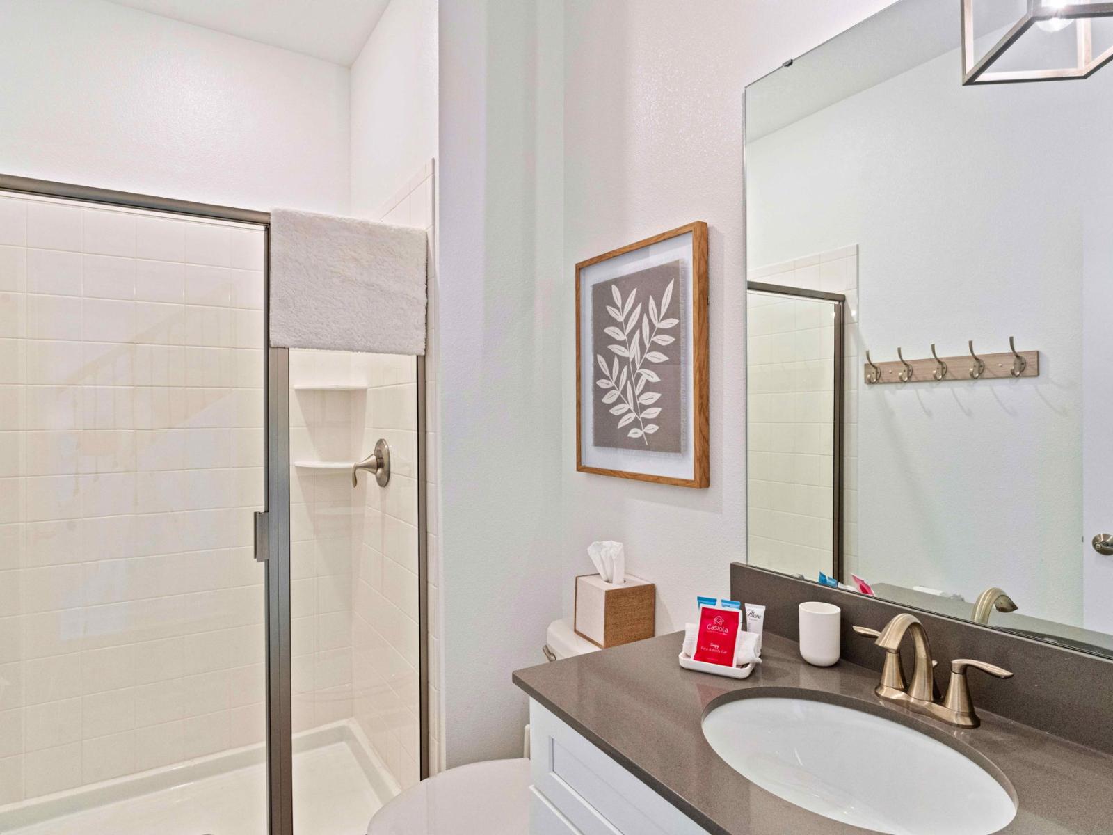 Polished bathroom of the townhouse in Kissimmee Florida - Featuring a sleek walk-in shower stall - Where modern elegance meets functionality - Offering a refreshing retreat after a day of adventure