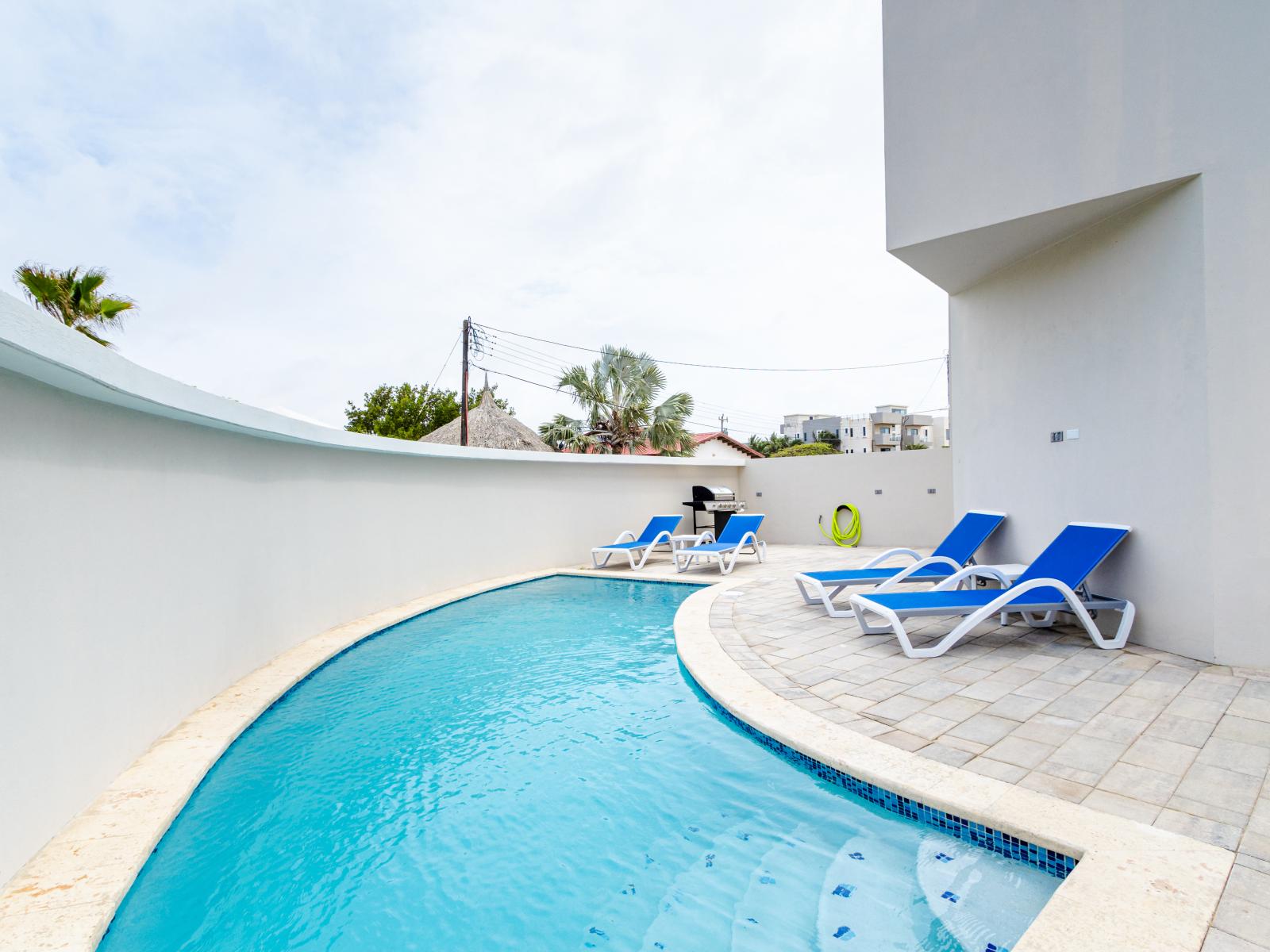 Posh Pool of the 2-BR Condo in Noord Aruba - Relax by the shimmering poolside oasis - Dive into a refreshing poolside escape - Experience ultimate relaxation in our poolside paradise - Comfy Beach Chair